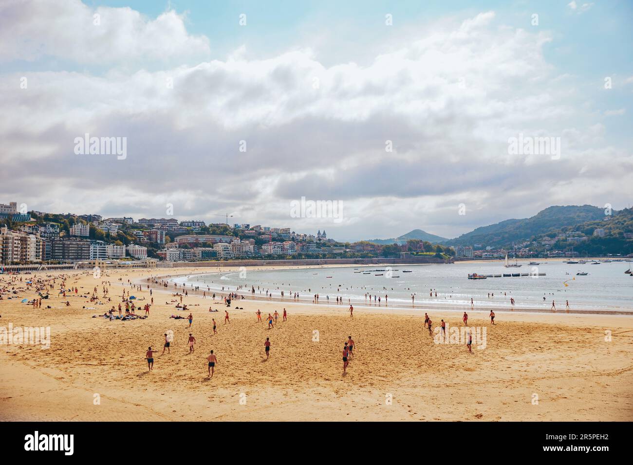 Foule de personnes appréciant des vacances d'été sur la plage de sable de la Concha contre des immeubles d'appartements le jour ensoleillé à Donostia San Sebastian, pays Basque, S Banque D'Images
