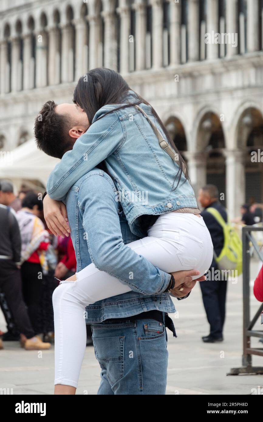 Dans une démonstration publique d'affection, un couple est très heureux de se voir. Sur la place Saint-Marc à Venise, en Italie. Banque D'Images