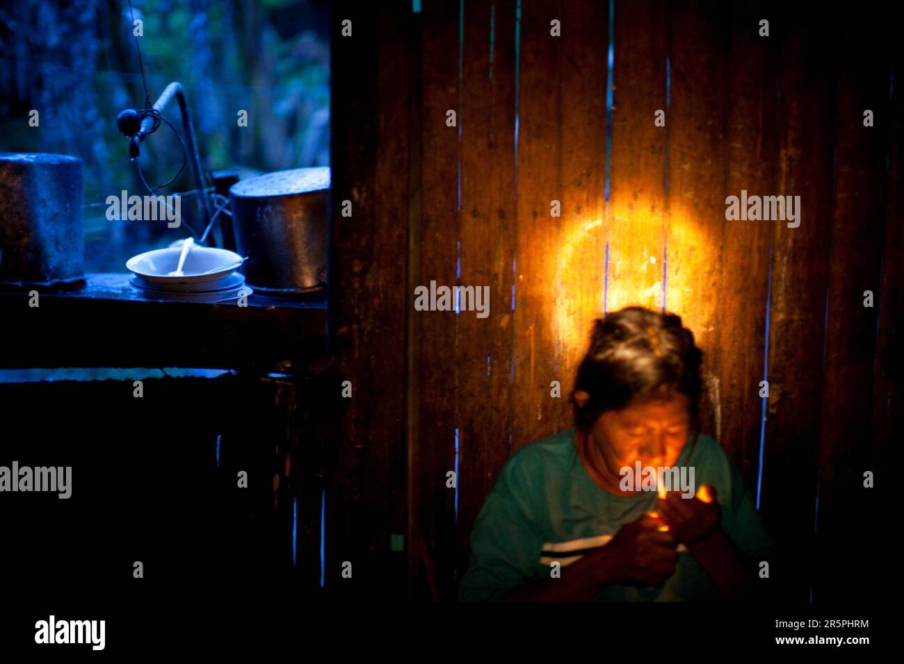 Une femme Oro Win allume une cigarette roulée à la main, Sao Luis Indian Post, Brésil. Banque D'Images