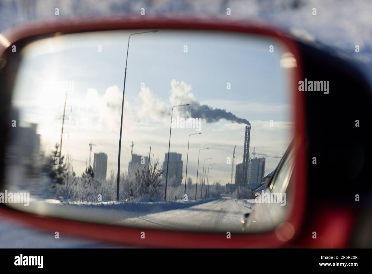 Reflet du paysage urbain dans le rétroviseur de la voiture lors d'une journée hivernale glacielle Banque D'Images