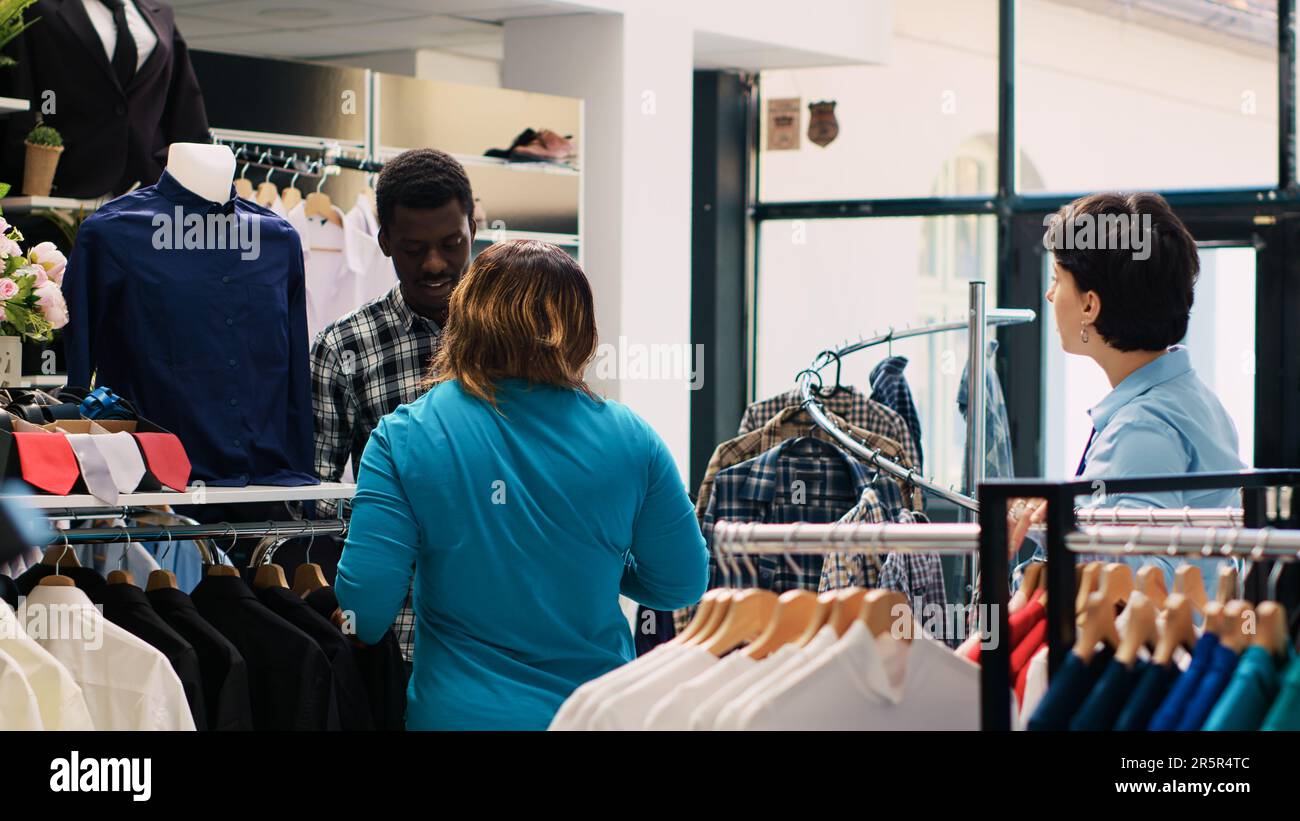 Client Afro-américain Regardant Des Cintres Pleins De Vêtements à La Mode  Dans Une Boutique Moderne