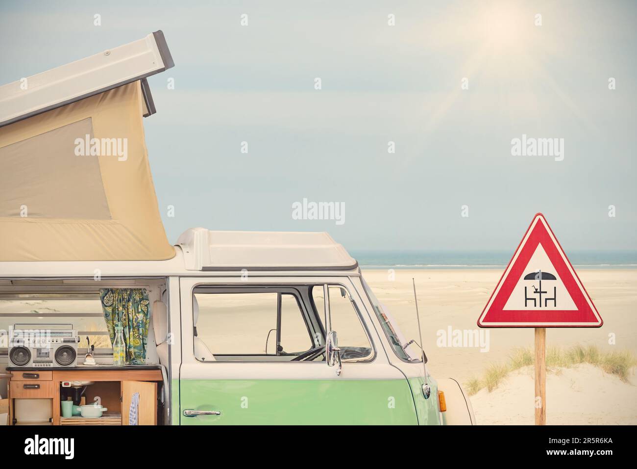 Vue latérale d'une maison à moteur des années 70 et panneau pique-nique devant une plage avec ciel bleu Banque D'Images