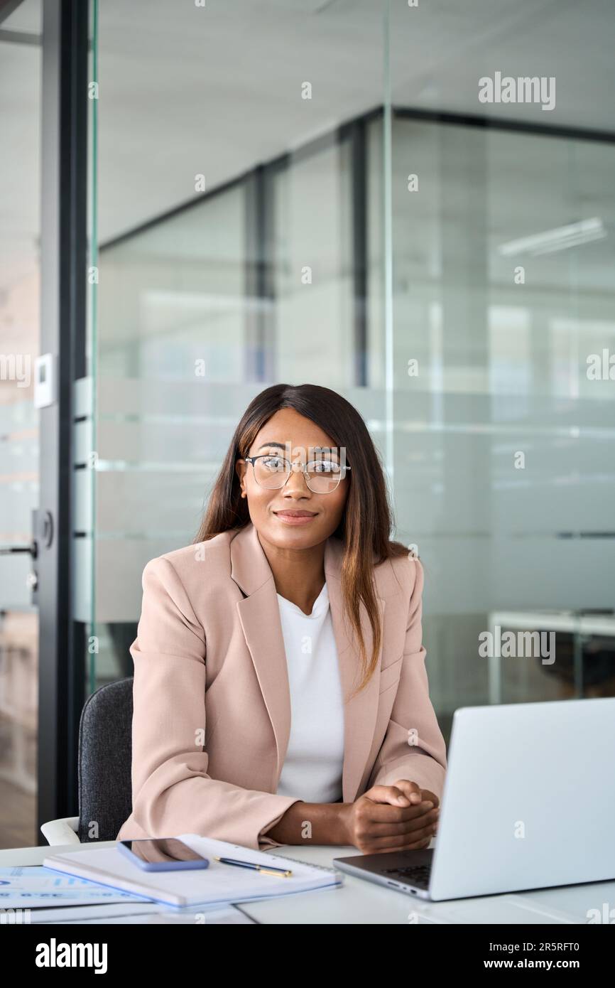 Jeune avocate confiante assise au bureau, portrait vertical. Banque D'Images
