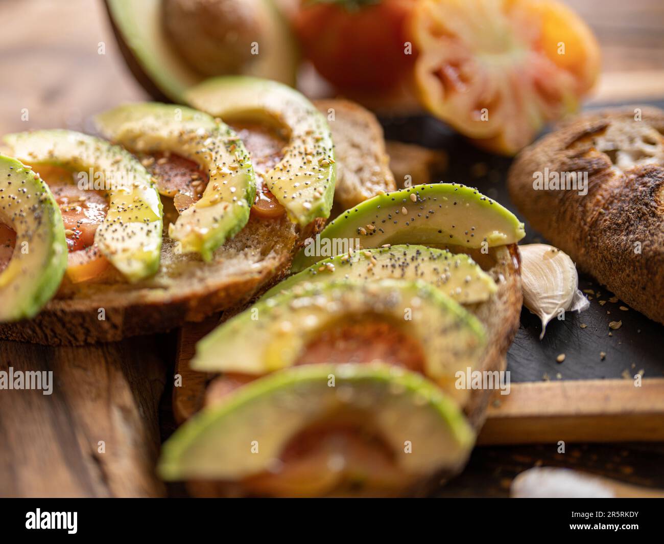 Levain de seigle fraîchement cuit coupé en tranches de pain artisanal bio avec tomate, ail, huile EVO, avocat, sel Banque D'Images