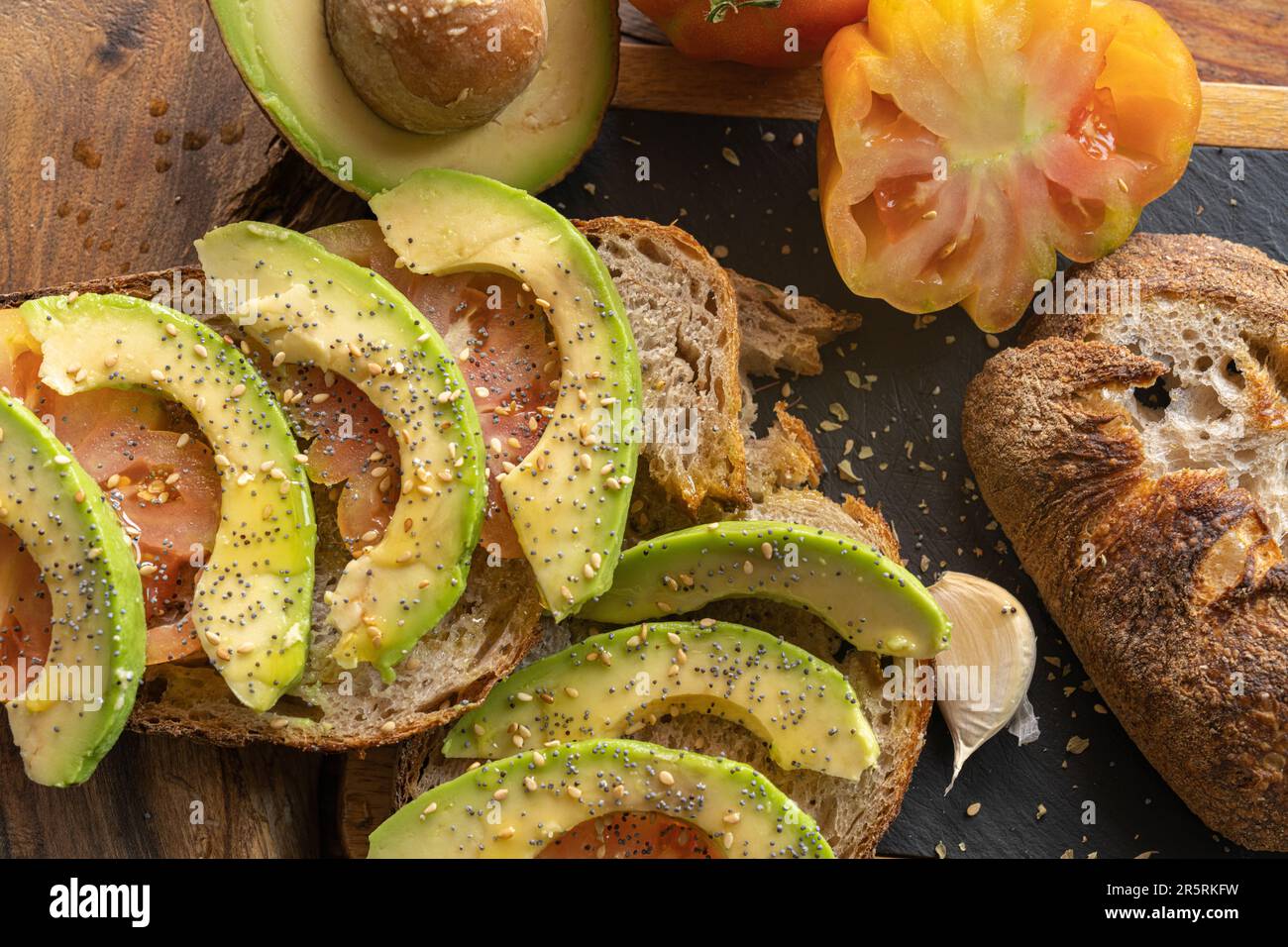Levain de seigle fraîchement cuit coupé en tranches de pain artisanal bio avec tomate, ail, huile EVO, avocat, sel Banque D'Images