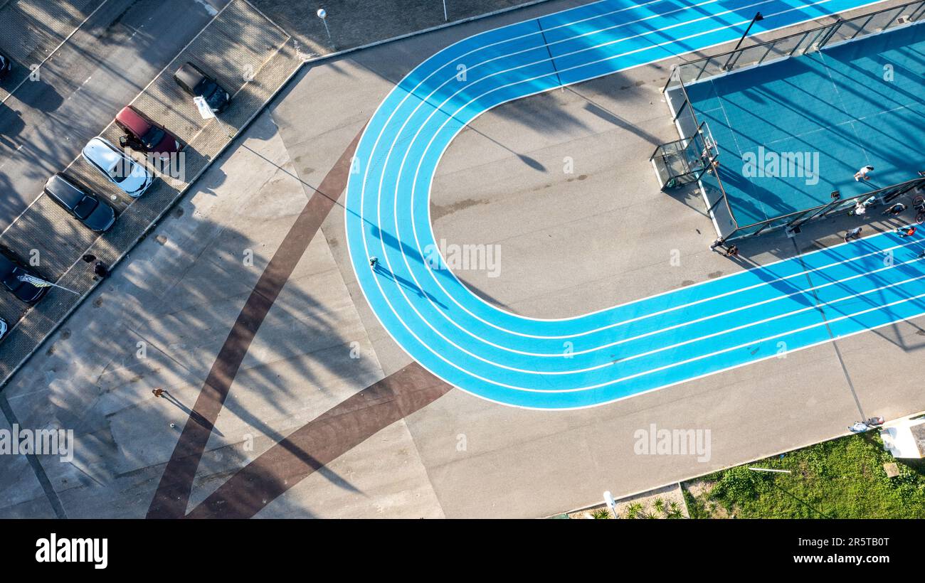 Piste de course bleue sur un terrain de sport public à côté d'un terrain de football et de basket-ball, vue d'en haut, photographie de drone, vue aérienne Banque D'Images