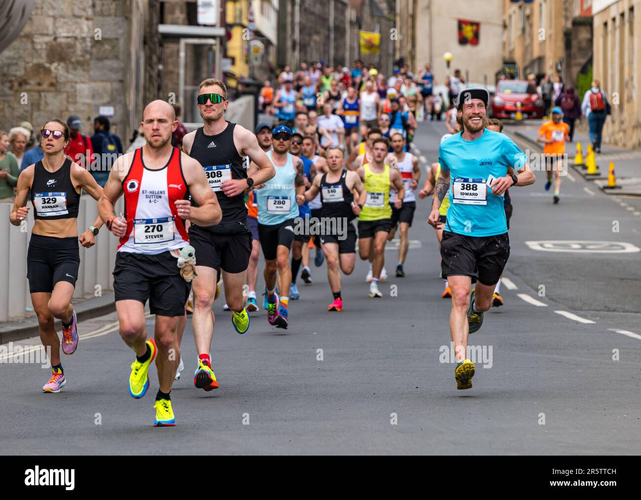 Coureurs qui participent au Marathon d'Édimbourg 2023 avec un participant souriant, Canongate, Royal Mile, Écosse, Royaume-Uni Banque D'Images
