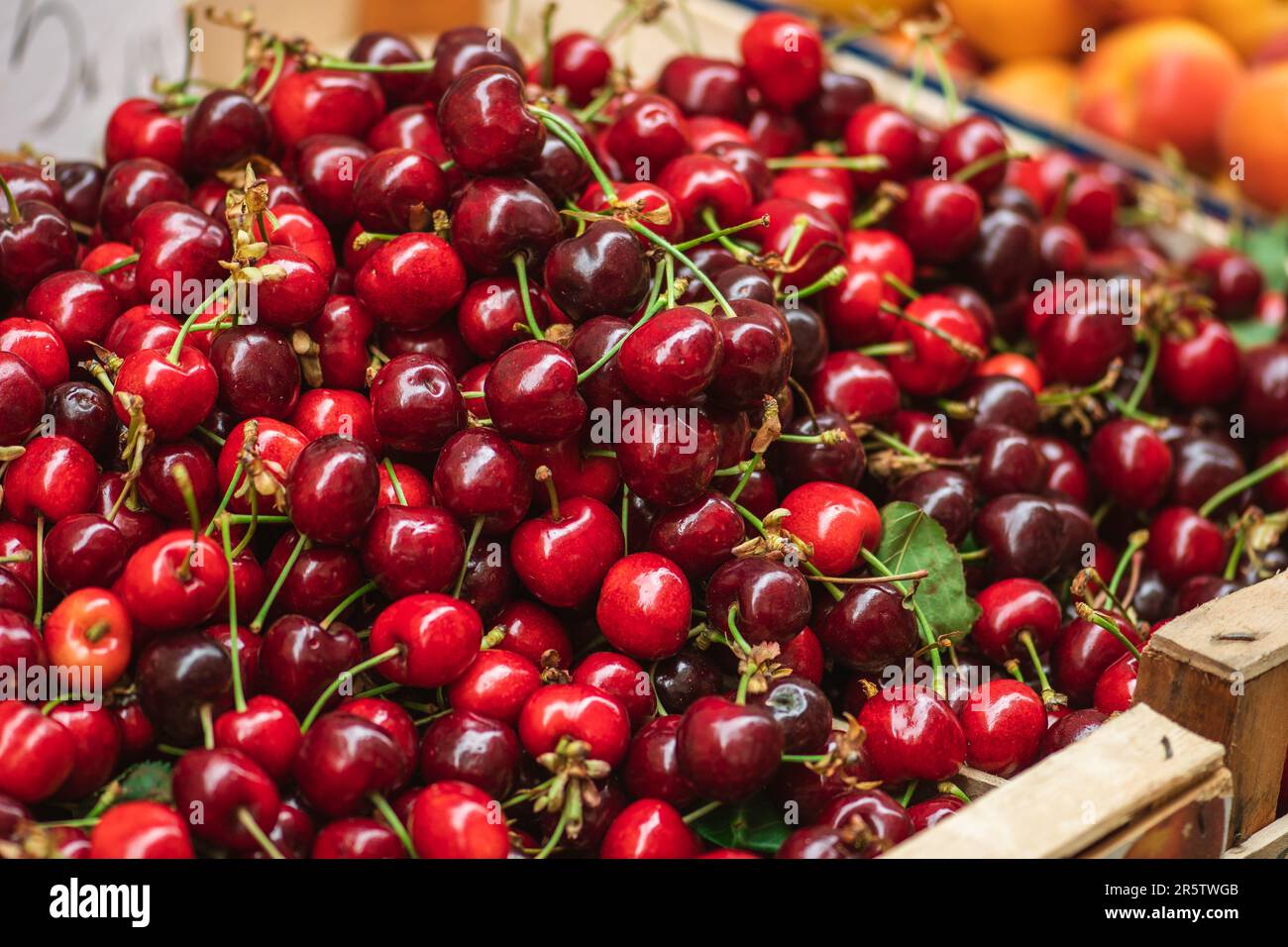 Cerise rouge mûre fraîche ou cerises fruits dans une boîte en bois dans un marché agricole en plein air, alimentation saine saisonnière. Concept de biologique, bio Banque D'Images