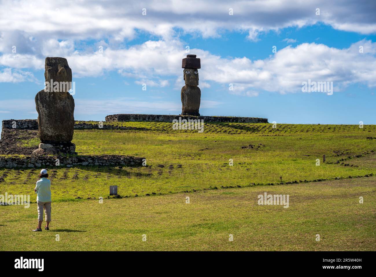 Île de Pâques, Chili -- 25 janvier 2023. Photo de deux statues Moai, une avec des yeux clairement visibles, et une femme touristique. Banque D'Images