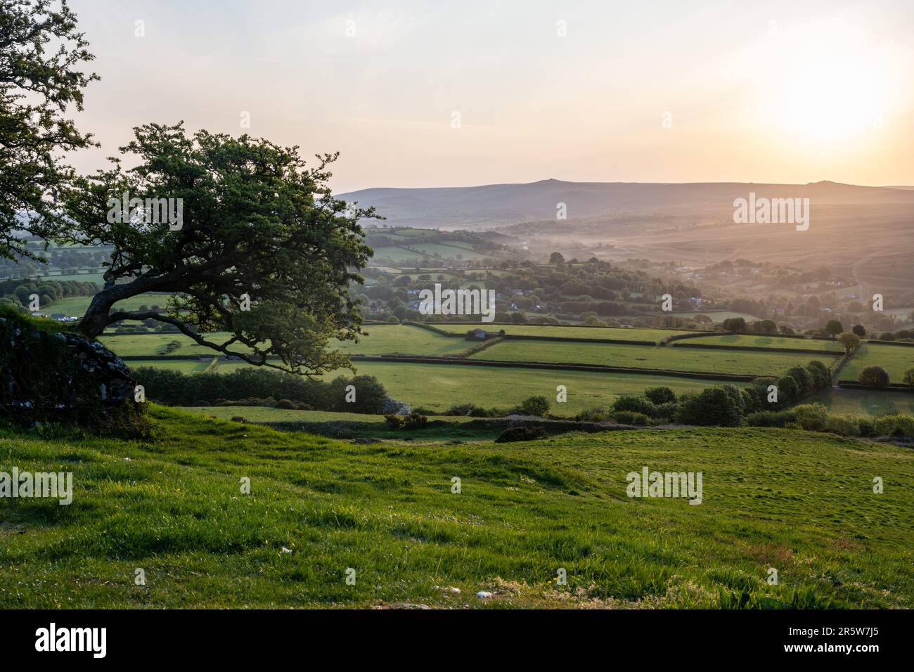 La brume s'élève des vallées autour de Lydford et de North Brentor sous les collines de Dartmoor au lever du soleil à West Devon, comme vu de Brent Tor. Banque D'Images