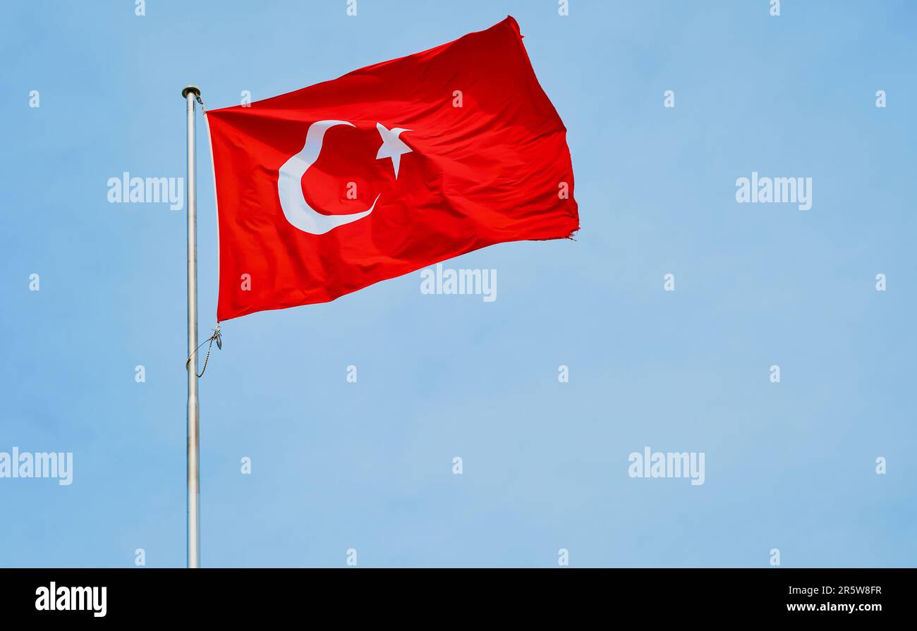 Drapeau de la République de Turquie flottant dans le vent contre un ciel bleu, fond avec espace de copie Banque D'Images