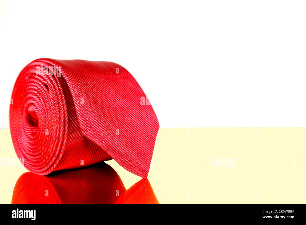 Un gros plan de la cravate d'un homme drapée sur un sac en cuir marron, mettant en valeur les couleurs et les textures des deux articles Banque D'Images