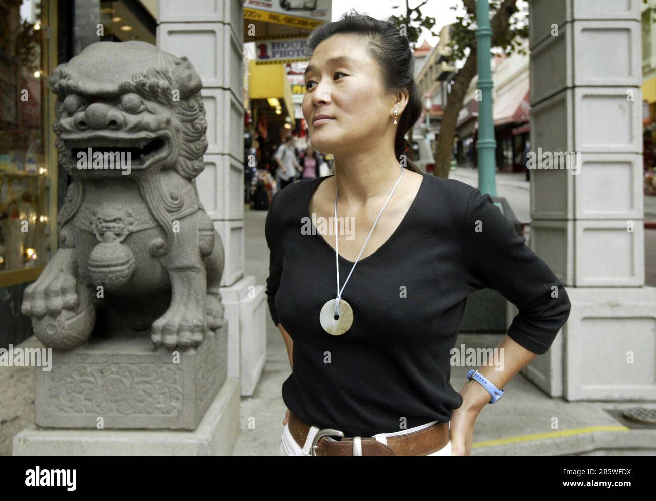yang_056_pc.jpg Belle Yang stopped at the entrance to Chinatown at Bush and Grant Sts. during a recent visit. Celebrated author/artist Belle Yang has come out with a children's book about her own family's experiences as new immigrants in SF. Yang visited her old apartment building on Bush St. in San Francisco on 8/24/04. PAUL CHINN/The Chronicle (PAUL CHINN/San Francisco Chronicle via AP) Banque D'Images