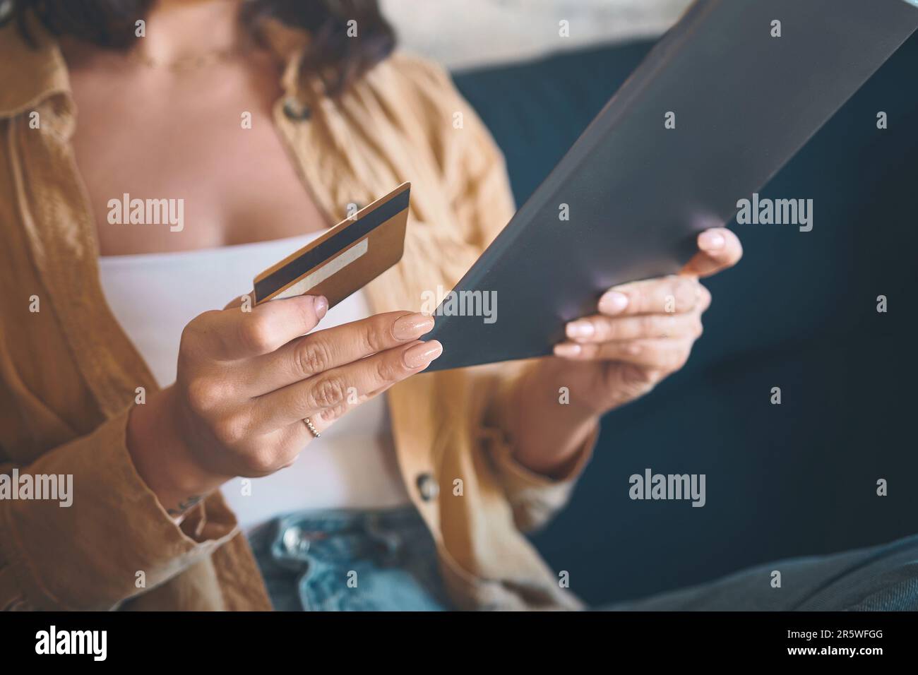 Vous ne pouvez pas acheter ce genre de commodité. une femme méconnaissable utilisant une tablette numérique et une carte de crédit sur le canapé à la maison. Banque D'Images
