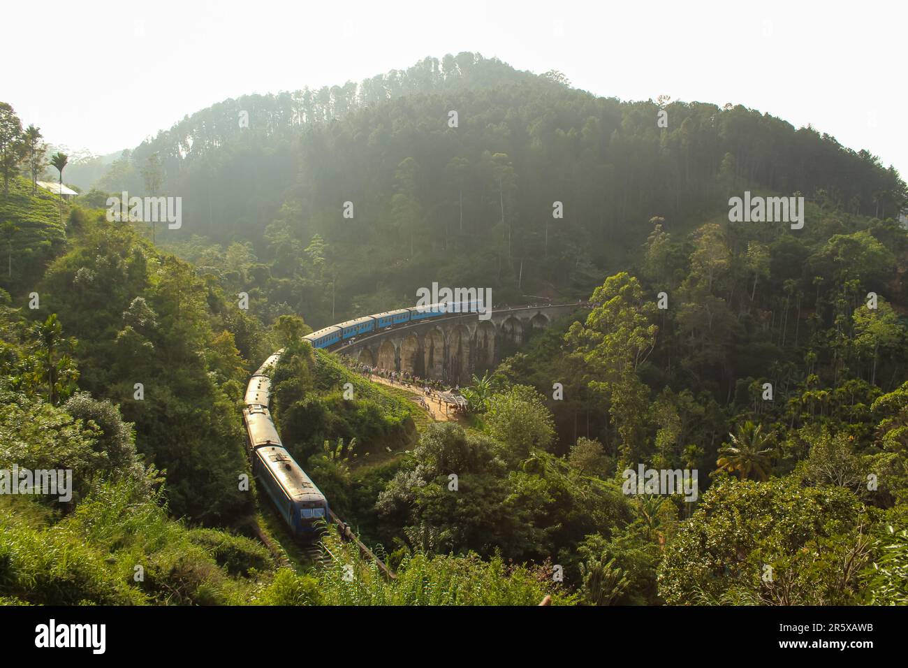 Train de passagers bleu passant par le célèbre et emblématique pont neuf Arches près d'Ella, Sri Lanka, coucher de soleil Banque D'Images