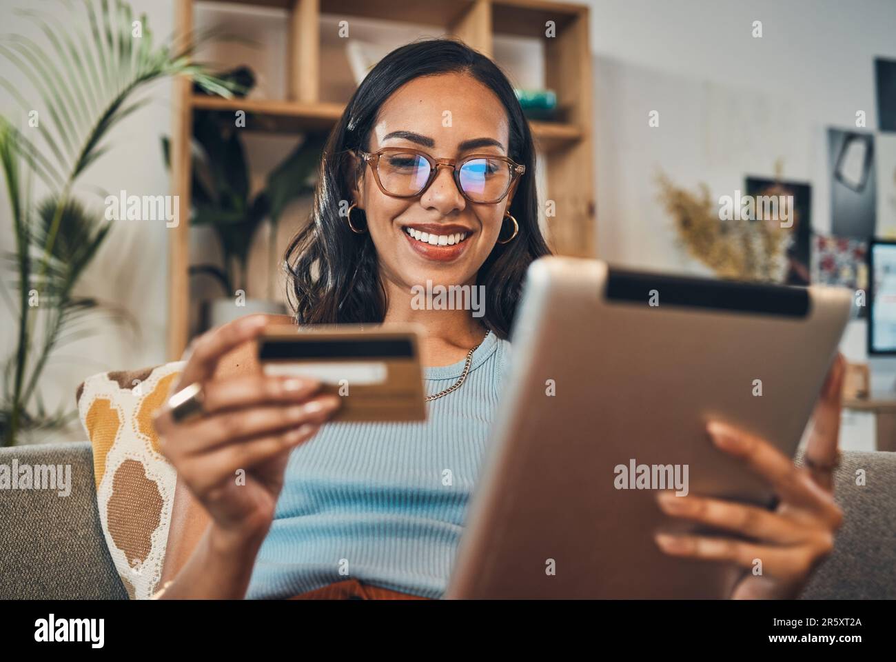 Femme sur le canapé avec tablette, carte de crédit et ecommerce paiement pour les achats en ligne avec fintech à la maison. Client féminin satisfait, application de banque numérique et Banque D'Images