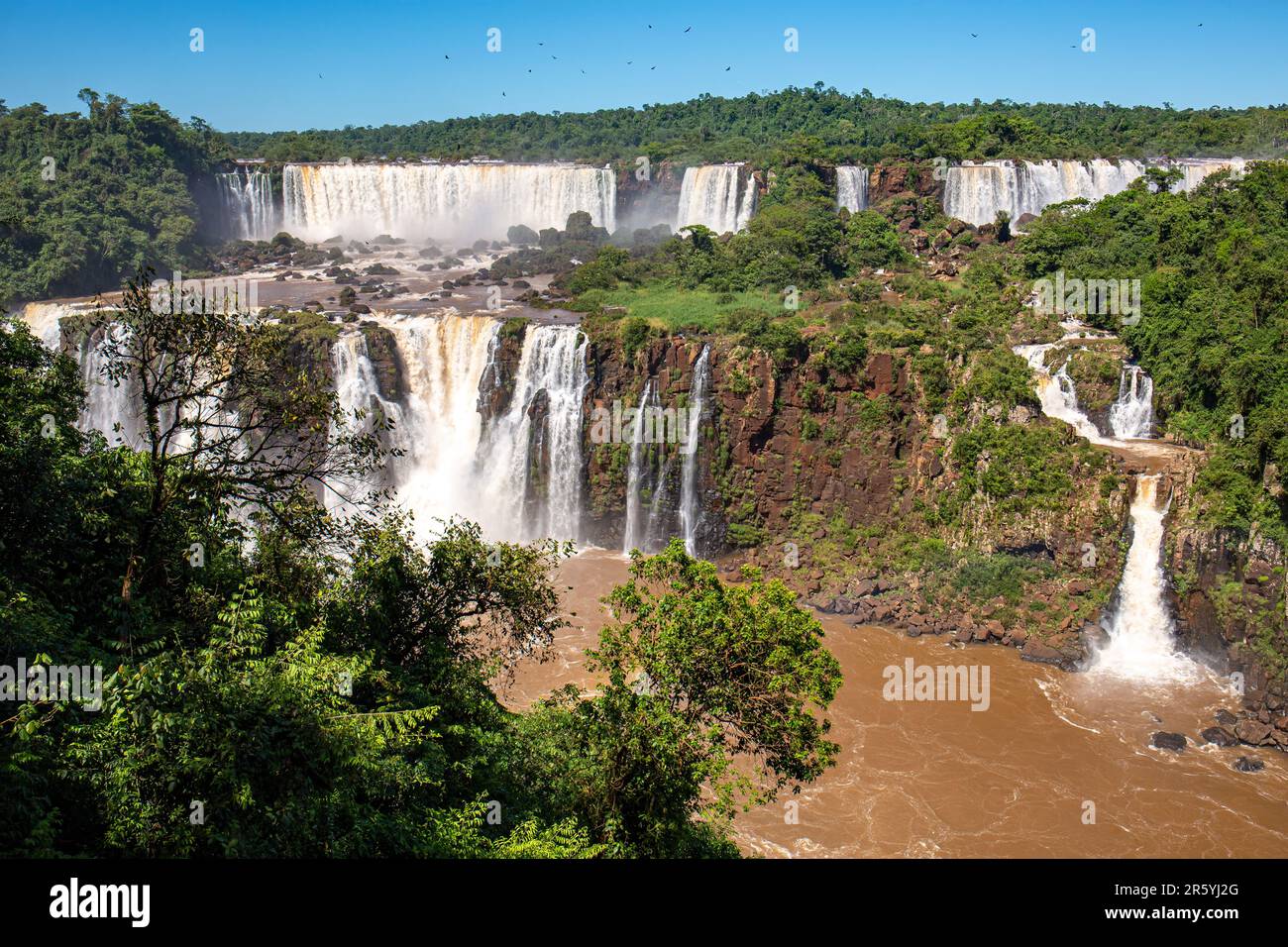 Vue sur les spectaculaires chutes d'Iguazu avec l'île de San Martin, Salto Tres Mosquetetos (trois mousquetaires) et Salto Rivadavia au soleil, en Argentine Banque D'Images