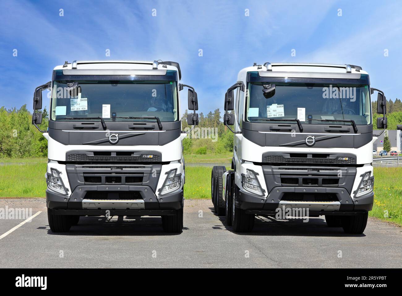 Deux nouveaux camions poids lourd Volvo FMX blancs pour la construction stationnés sur une cour d'asphalte. Forssa, Finlande. 10 juin 2022. Banque D'Images