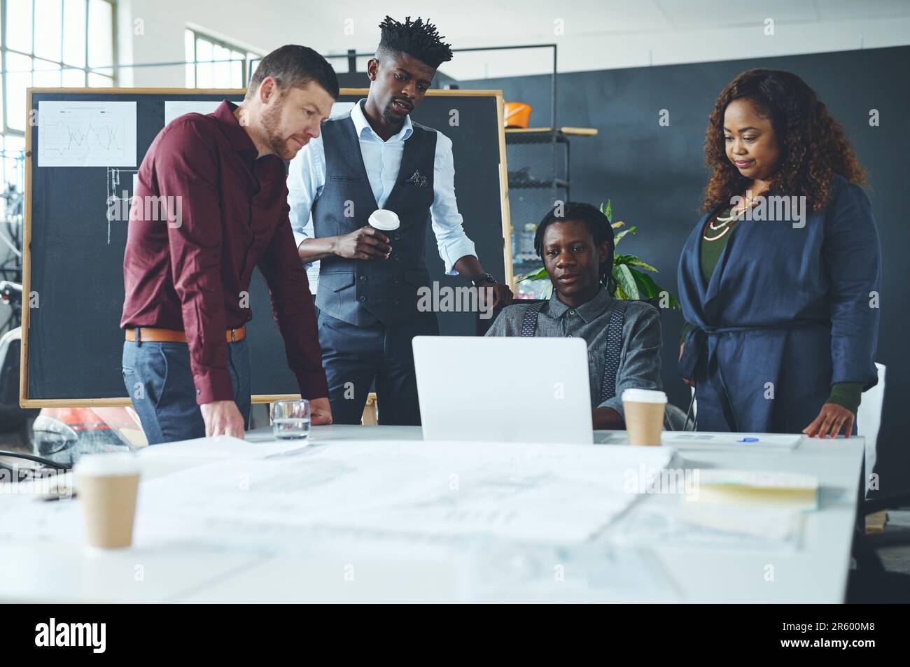 Collaborer sur un projet important. un groupe de collègues discutant de quelque chose sur un ordinateur portable pendant une réunion. Banque D'Images