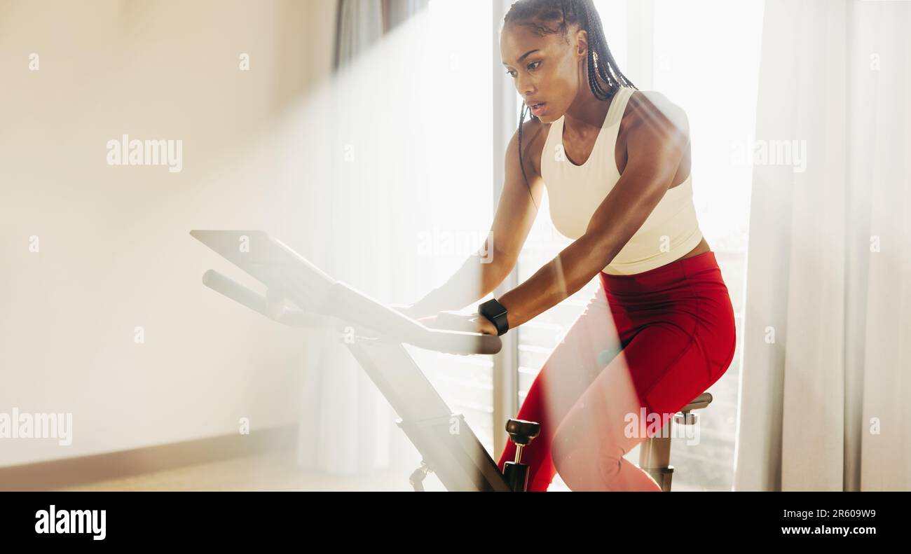 Une athlète féminine noire écrasant son entraînement cardio avec son équipement d'exercice à la maison, en utilisant son entraînement et sa détermination pour atteindre ses objectifs de forme physique. Vous Banque D'Images