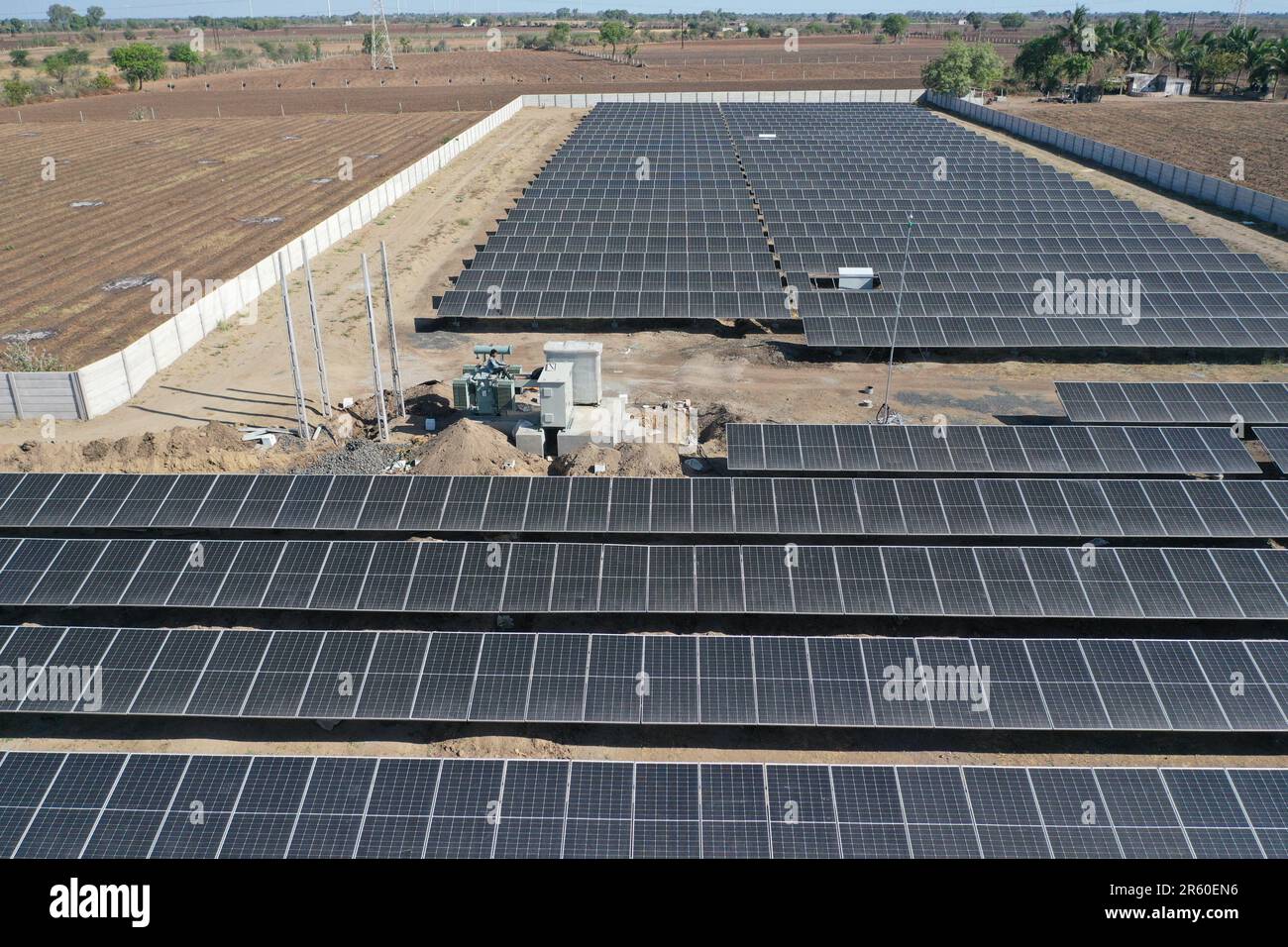 Une vue aérienne d'une grande ferme solaire avec un ensemble de panneaux solaires noirs disposés en rangées nettes Banque D'Images