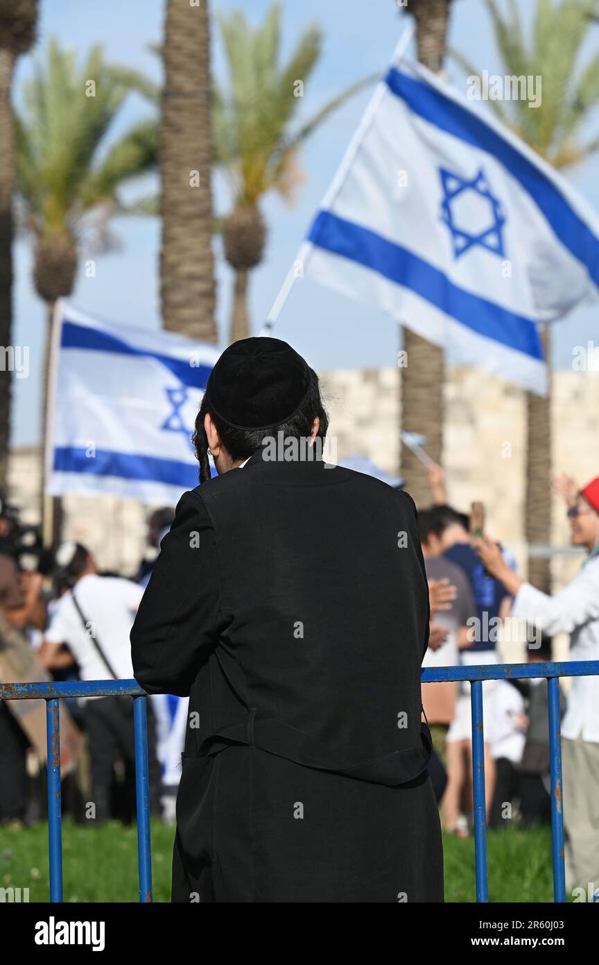 Un adolescent de Haredi regardant les drapeaux israéliens Banque D'Images
