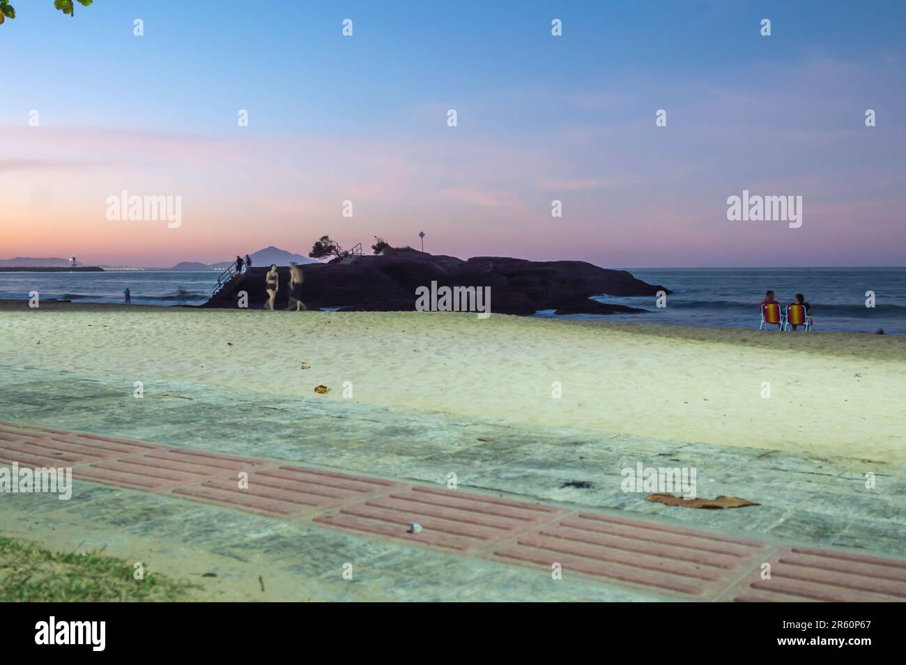 Plage de Cabeçudas dans itajai-sc brésil, en fin d'après-midi et les gens sur leur dos appréciant la plage, cargo arrivant dans la ville en arrière-plan, s Banque D'Images
