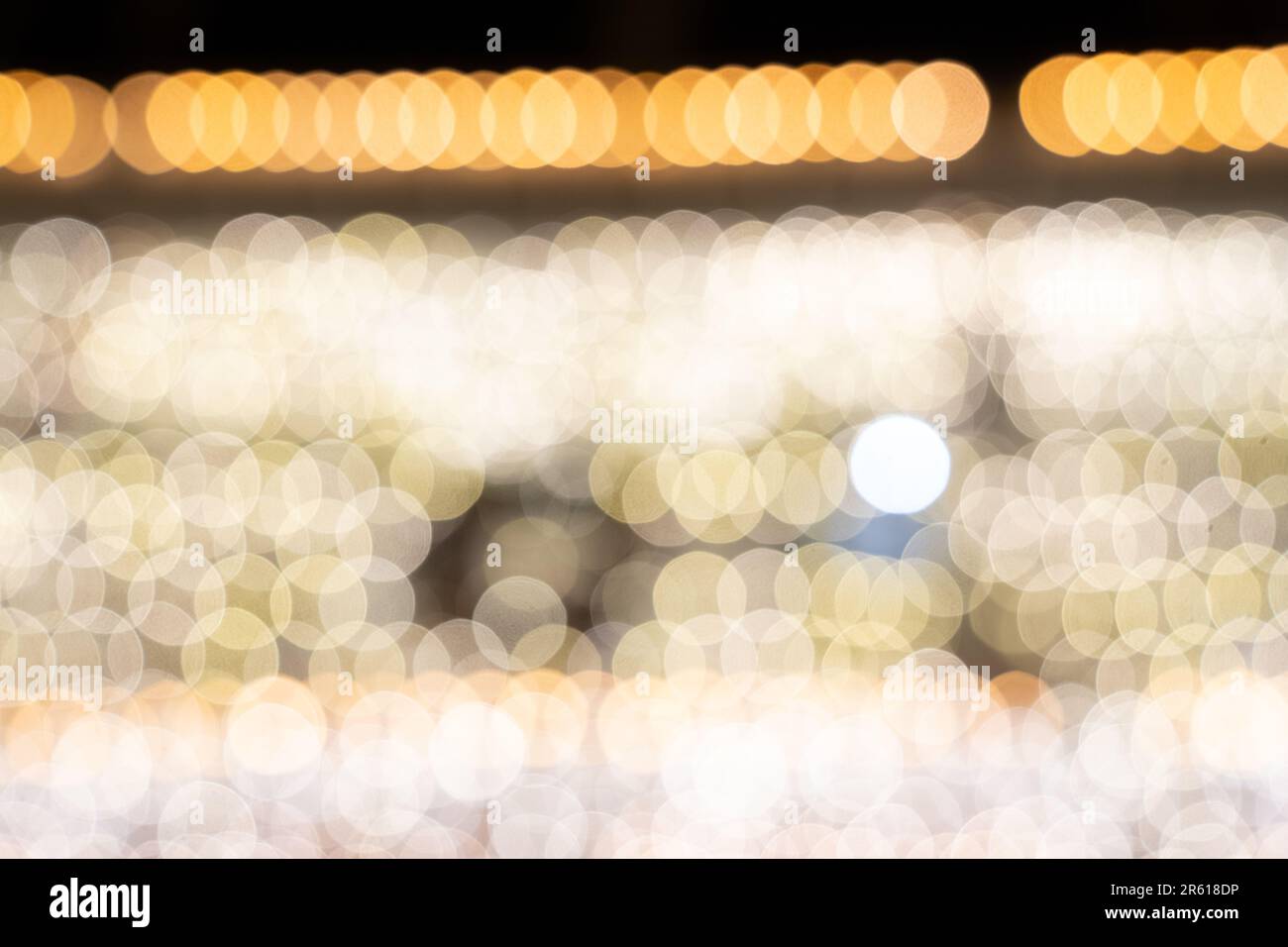 Des rangées de boules de bokeh blanches, des lumières de Noël défocurées. Utile pour les arrière-plans Banque D'Images