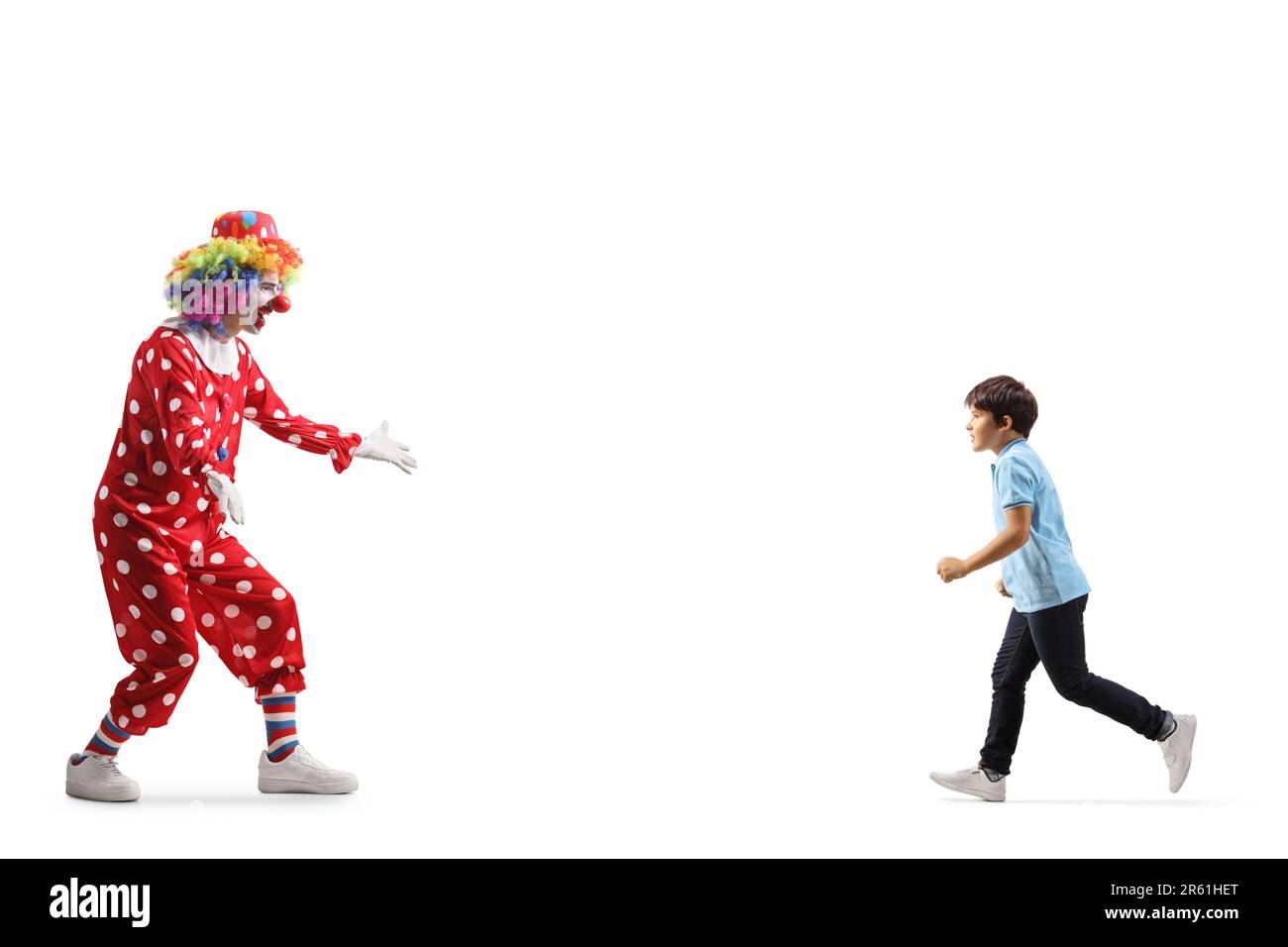 Garçon courant vers un clown isolé sur fond blanc Banque D'Images