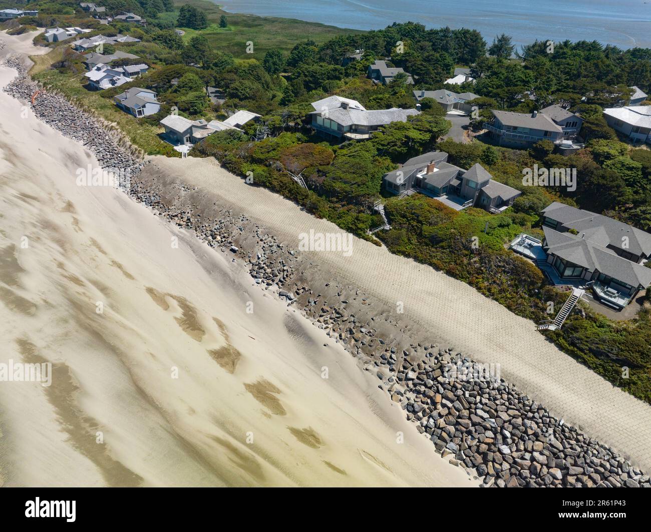 Le riprap - une construction de grandes roches - protège contre l'élévation du niveau de la mer sur la côte de l'Oregon de l'océan Pacifique. La mesure temporaire peut coûter plus de $1000 par pied linéaire et est supportée dans ce cas par le propriétaire. Banque D'Images
