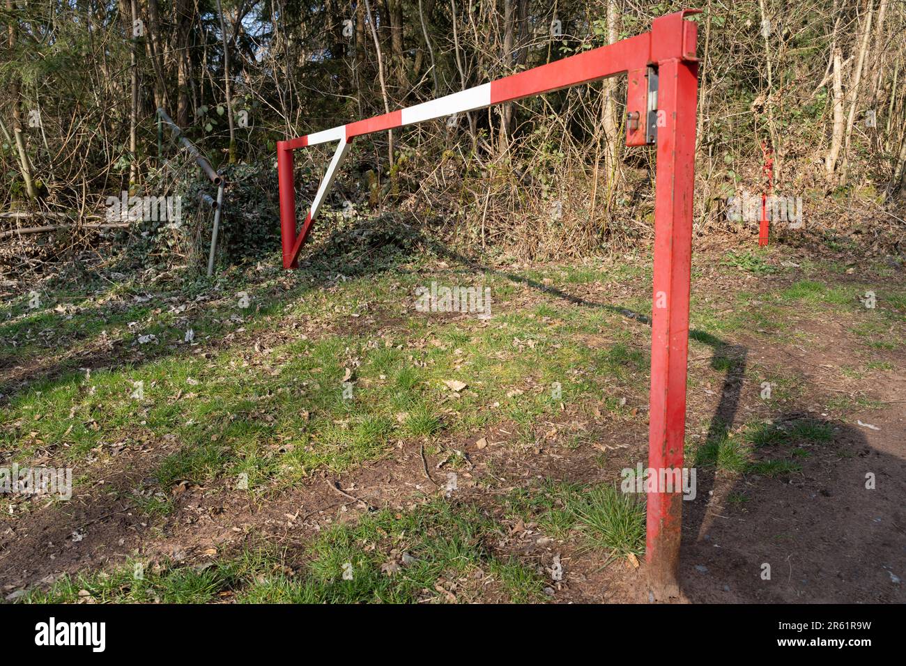 Barrière métallique rouge avec bandes blanches dans la forêt Banque D'Images