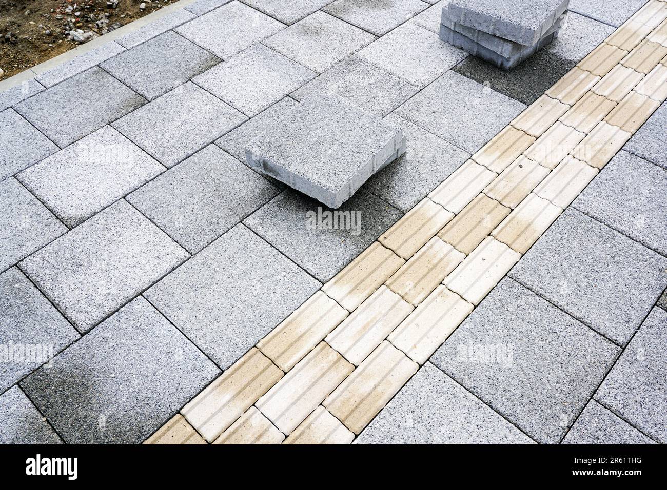 Un nouveau trottoir pavé avec des lignes directrices intégrées pour les personnes malvoyantes, pavage tactile Banque D'Images