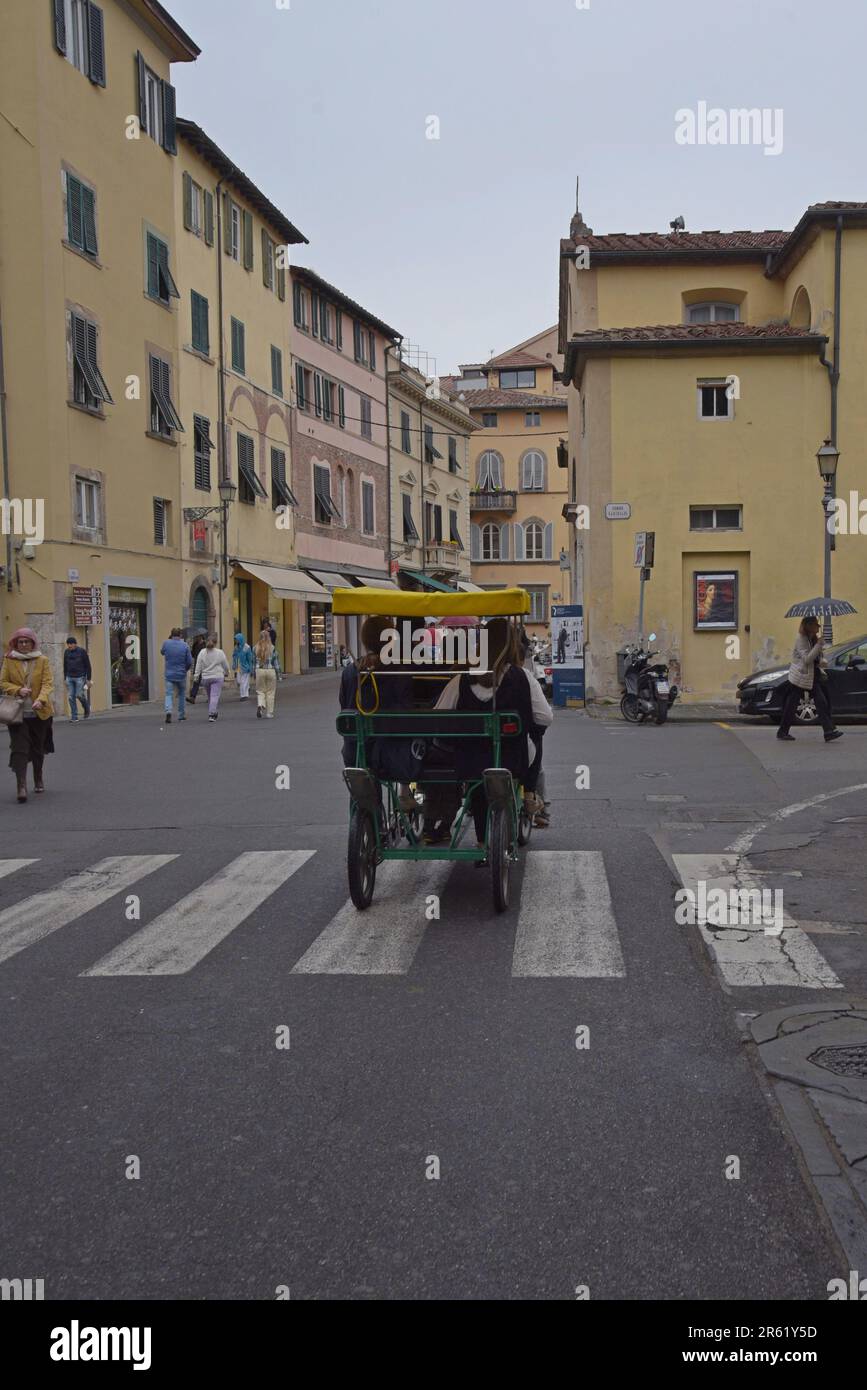 Les gens qui utilisent un voyage touristique de quatre places à Surrey louent un vélo dans la ville historique de Lucca, Toscane, Italie, avril 2023 Banque D'Images