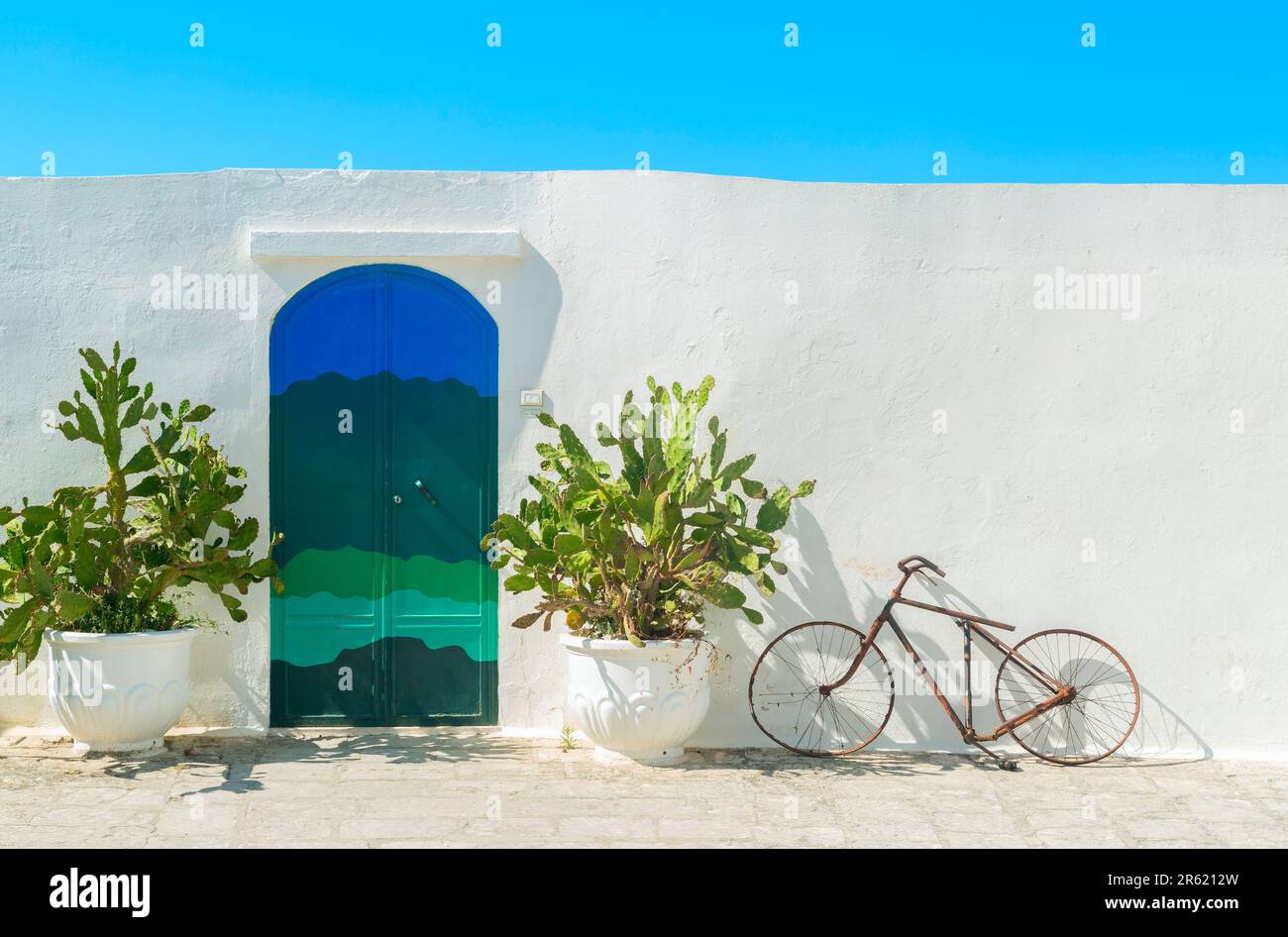 La porte bleue avec cactus et les murs blancs traditionnels de la ville d'Ostuni (Puglia - Italie). Banque D'Images