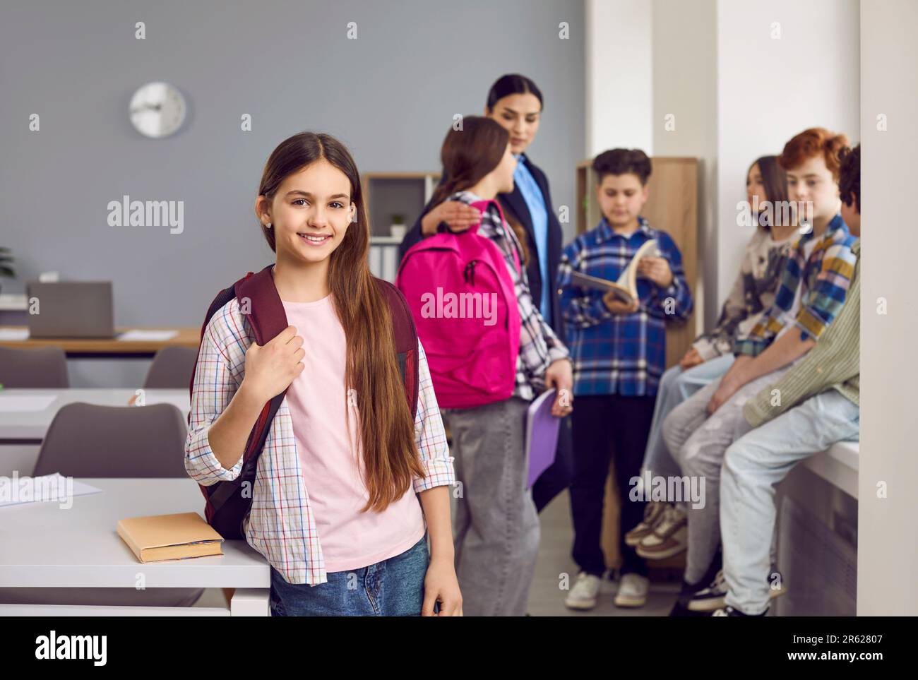 Portrait d'une jeune fille heureuse élève du primaire debout avec sac à dos Banque D'Images