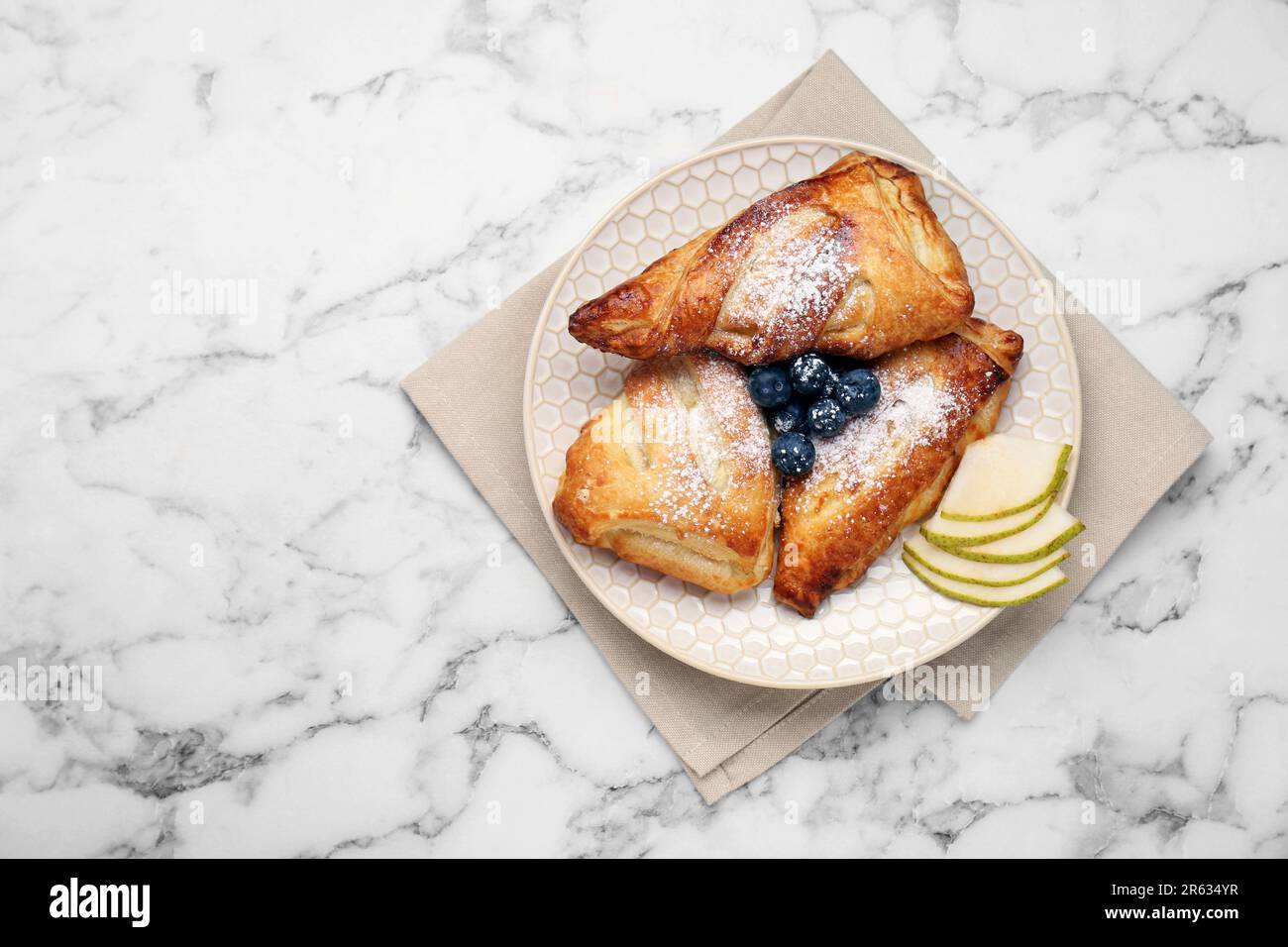 Savoureuse pâtisserie fraîche avec sucre en poudre, poire et bleuets servis sur une table en marbre blanc, vue du dessus. Espace pour le texte Banque D'Images