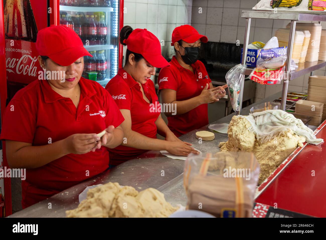 Femme roulant de la pâte de maïs pour faire des tortillas dans gordita fast food café restaurant, Merida, Yucatan State, Mexique Banque D'Images