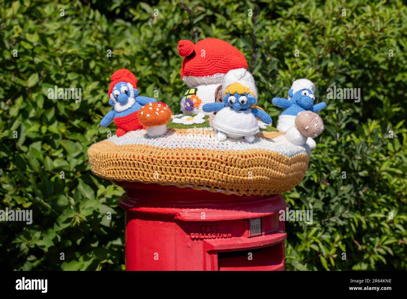 Crochet smurfs au-dessus d'une boîte postale à Carisbrooke, île de Wight, Angleterre, Royaume-Uni. Banque D'Images