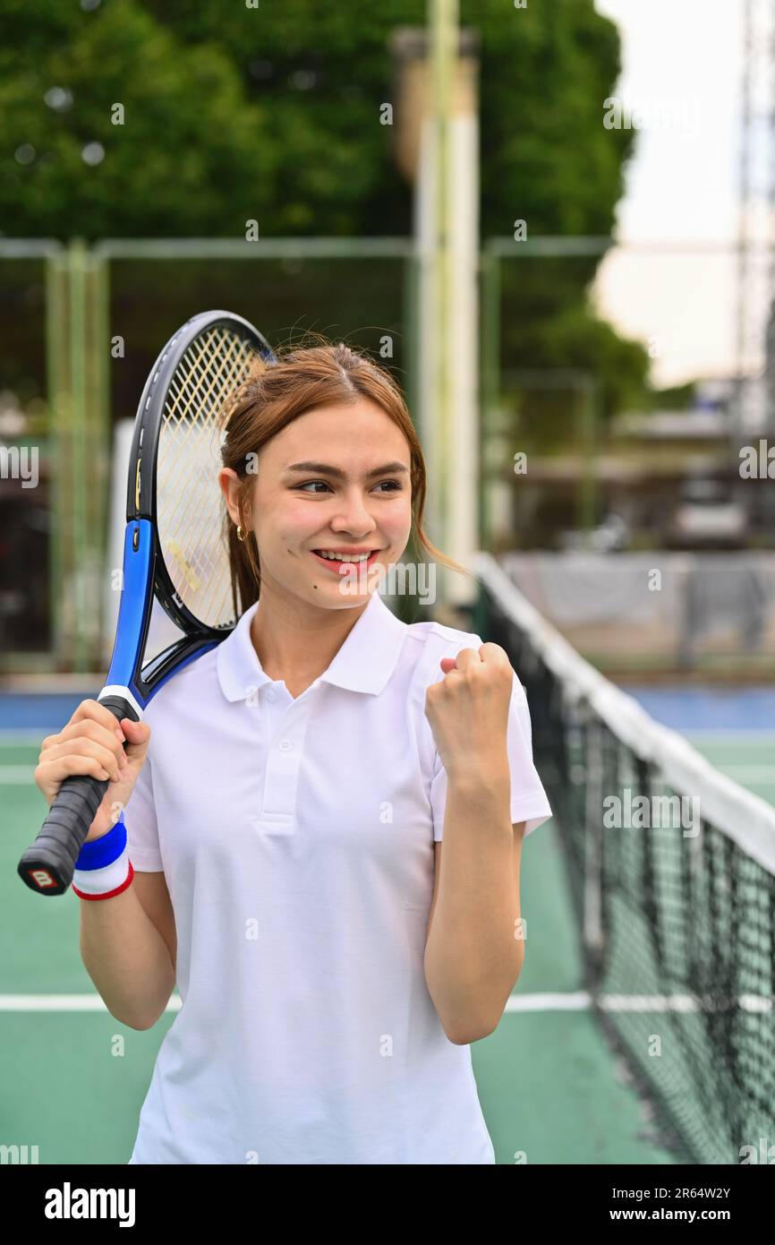 Bonne femme sportive avec raquette célébrant après avoir marqué sur le  court de tennis Photo Stock - Alamy