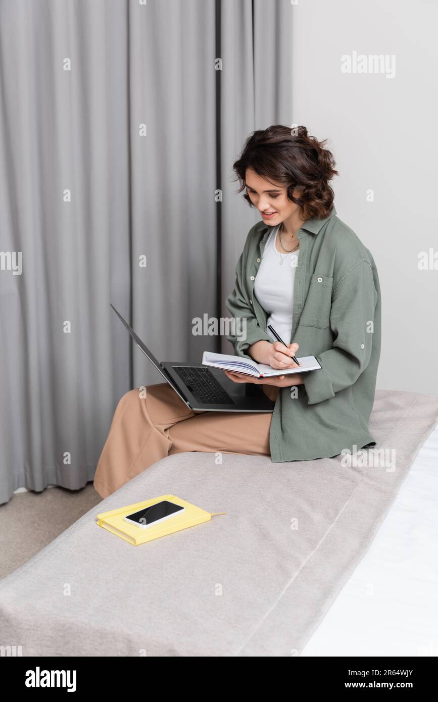 une jeune femme insouciante qui écrit dans un ordinateur portable et ...
