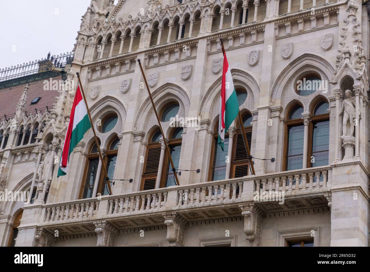 Drapeaux sur le magnifique vieux bâtiment du Parlement hongrois dans le style néo-gothique à Budapest Banque D'Images