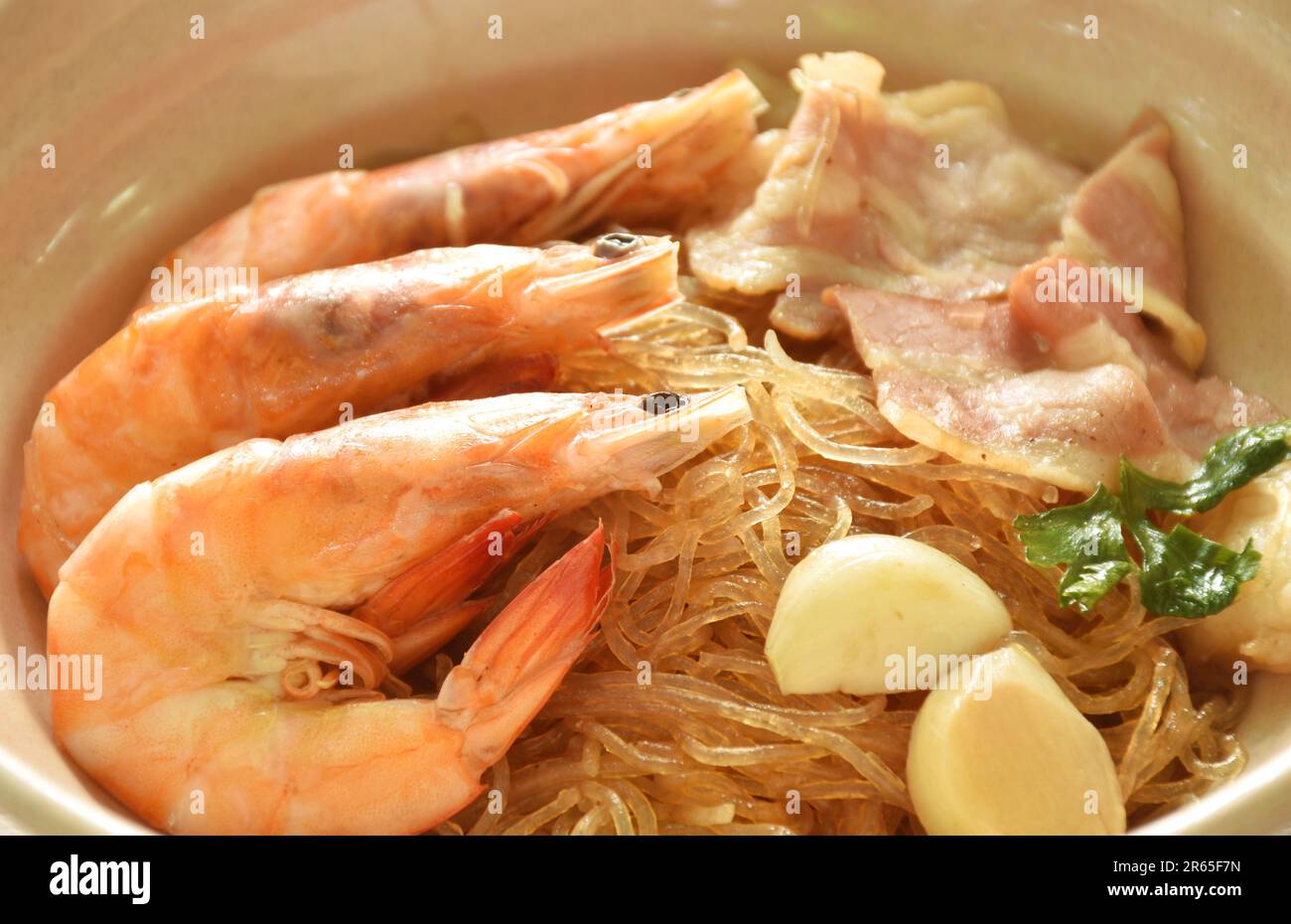 Bacon de crevettes et de porc cuit à la vapeur avec des nouilles en verre sur un bol en trempant une sauce Chili épicée aux fruits de mer thaïlandais Banque D'Images
