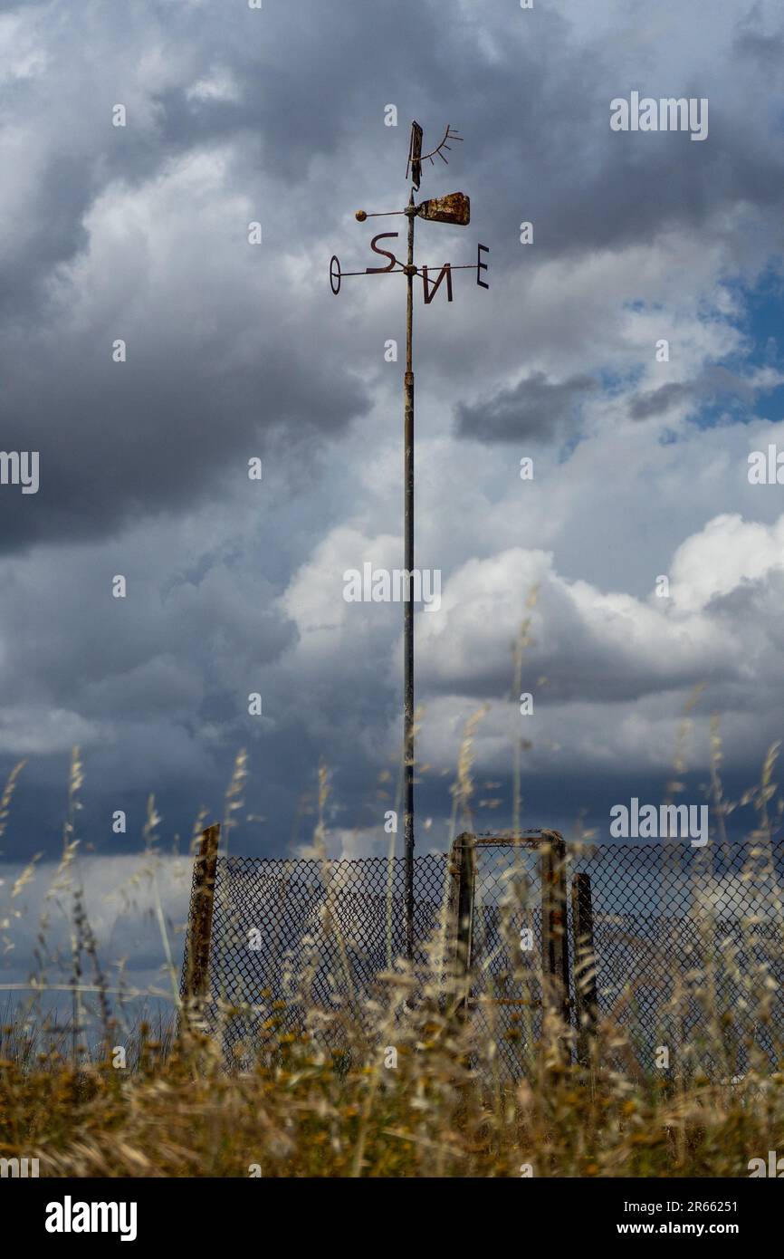Pinwheel avec les initiales des points cardinaux sur une journée nuageux. Banque D'Images
