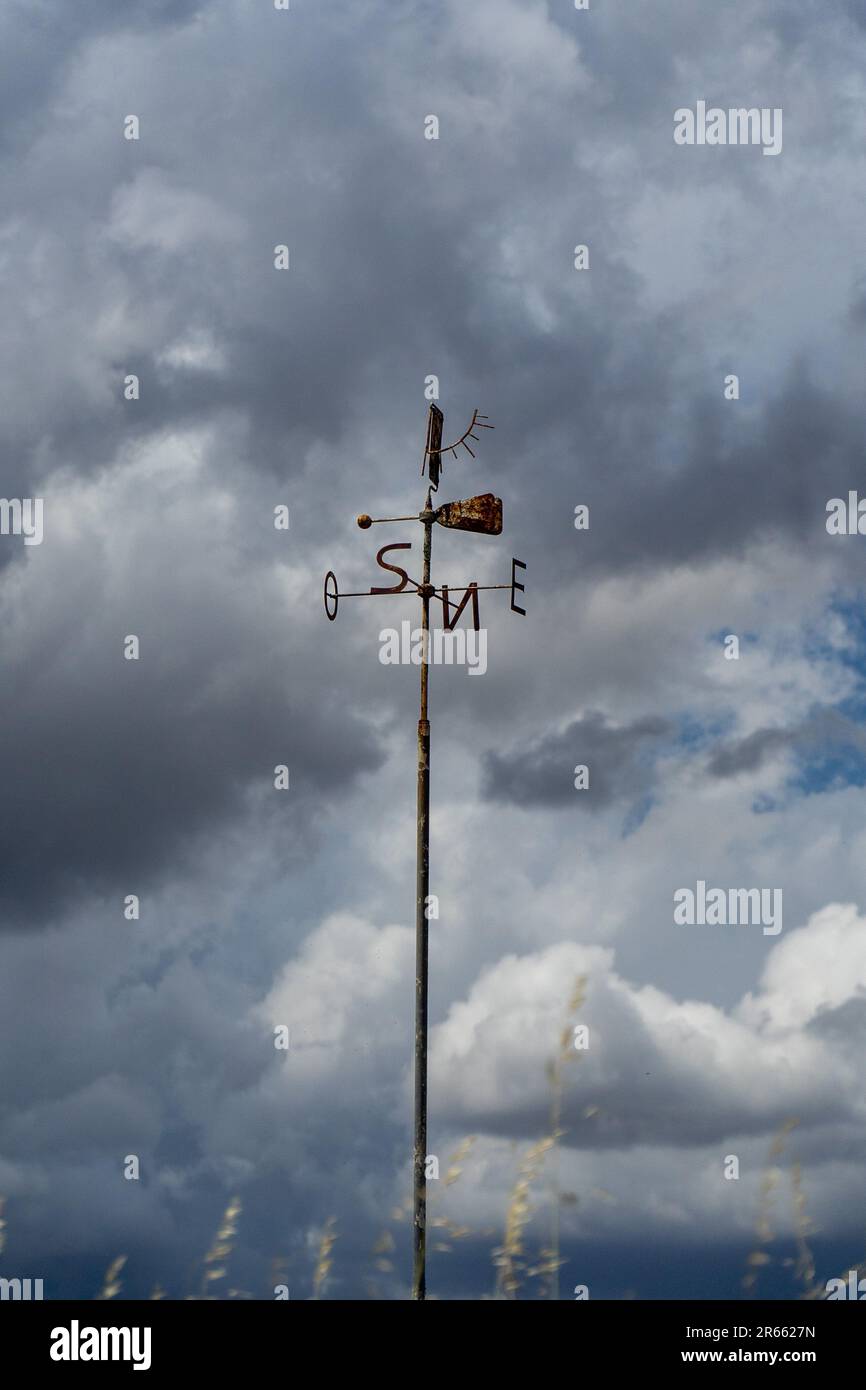 Pinwheel avec les initiales des points cardinaux sur une journée nuageux. Banque D'Images