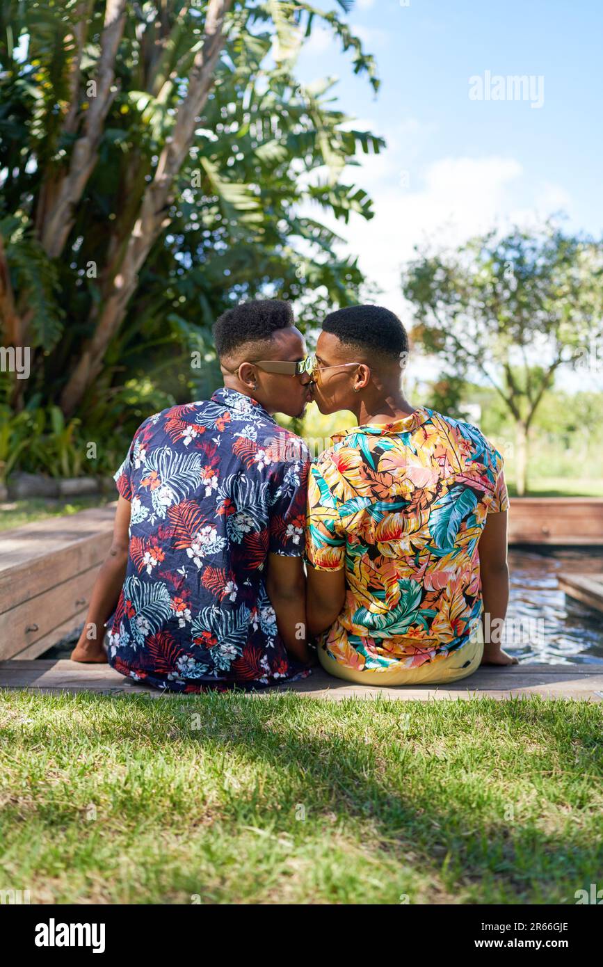 Un jeune homme gay affectueux embrasse à la piscine Banque D'Images