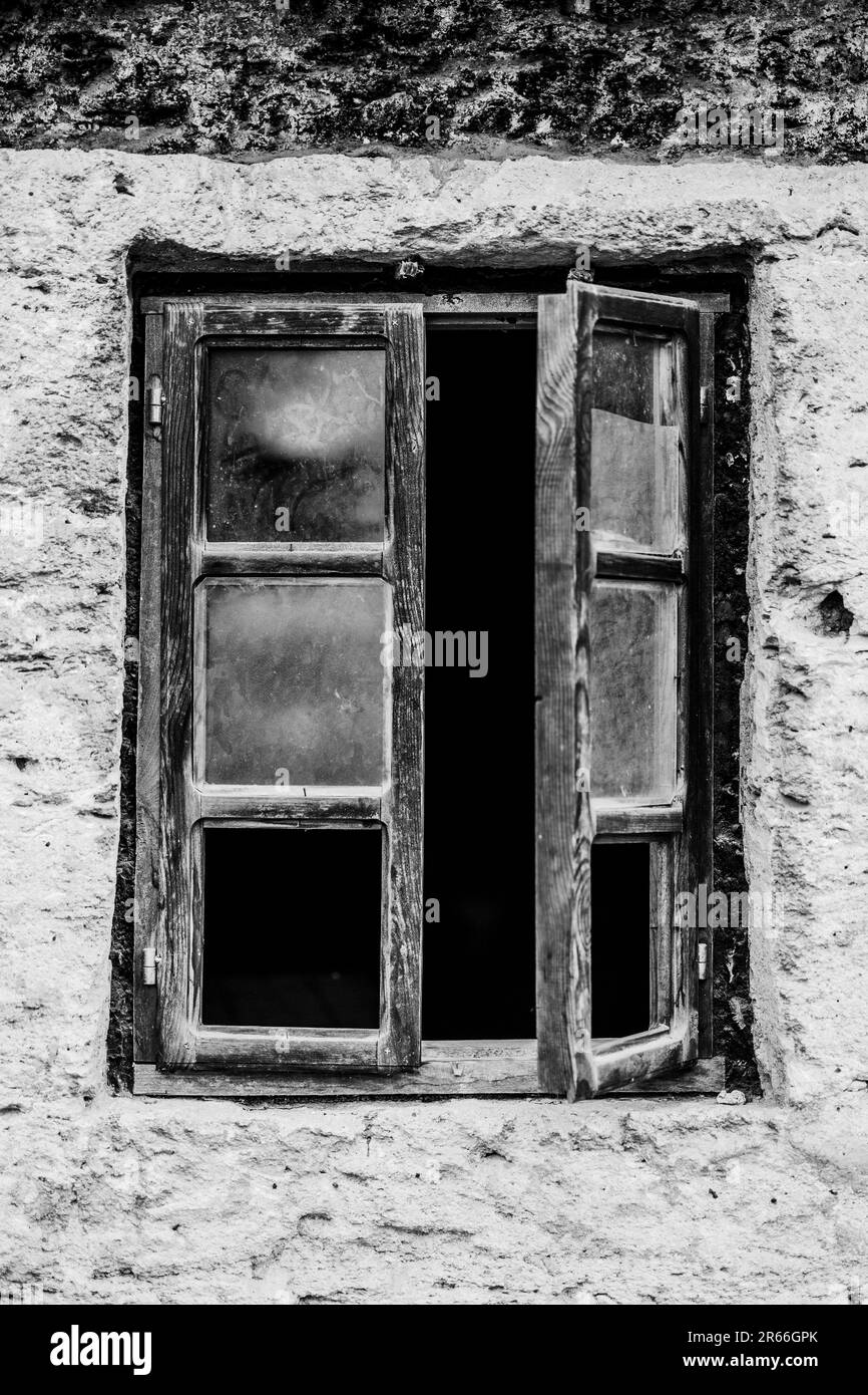 Une photo en noir et blanc d'une fenêtre ancienne et abandonnée Banque D'Images