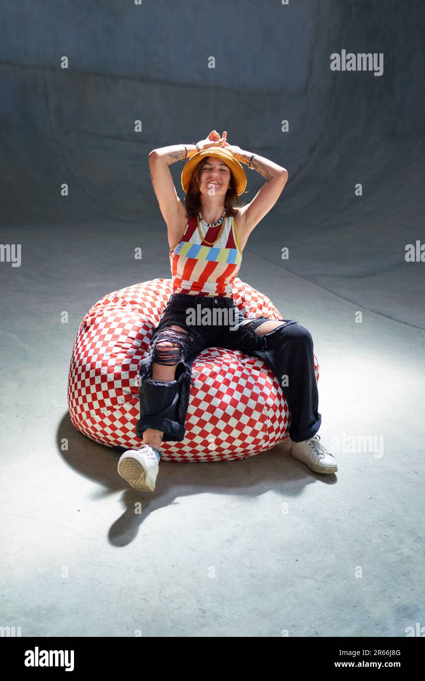 Portrait bonne, insouciante jeune femme dans la chaise de sac de haricot Banque D'Images