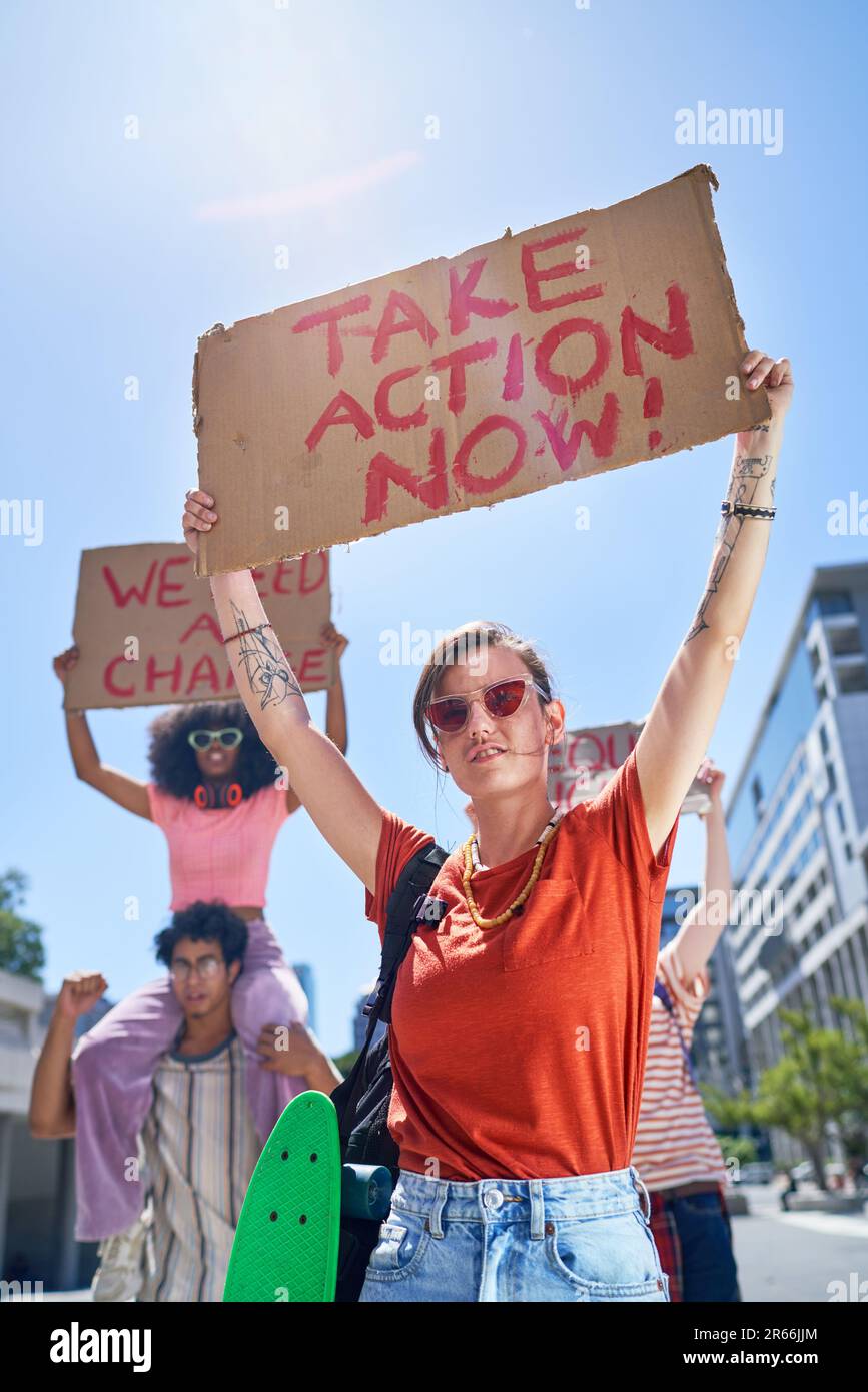 Portrait de jeunes manifestants tenant des panneaux de changement dans une ville ensoleillée Banque D'Images