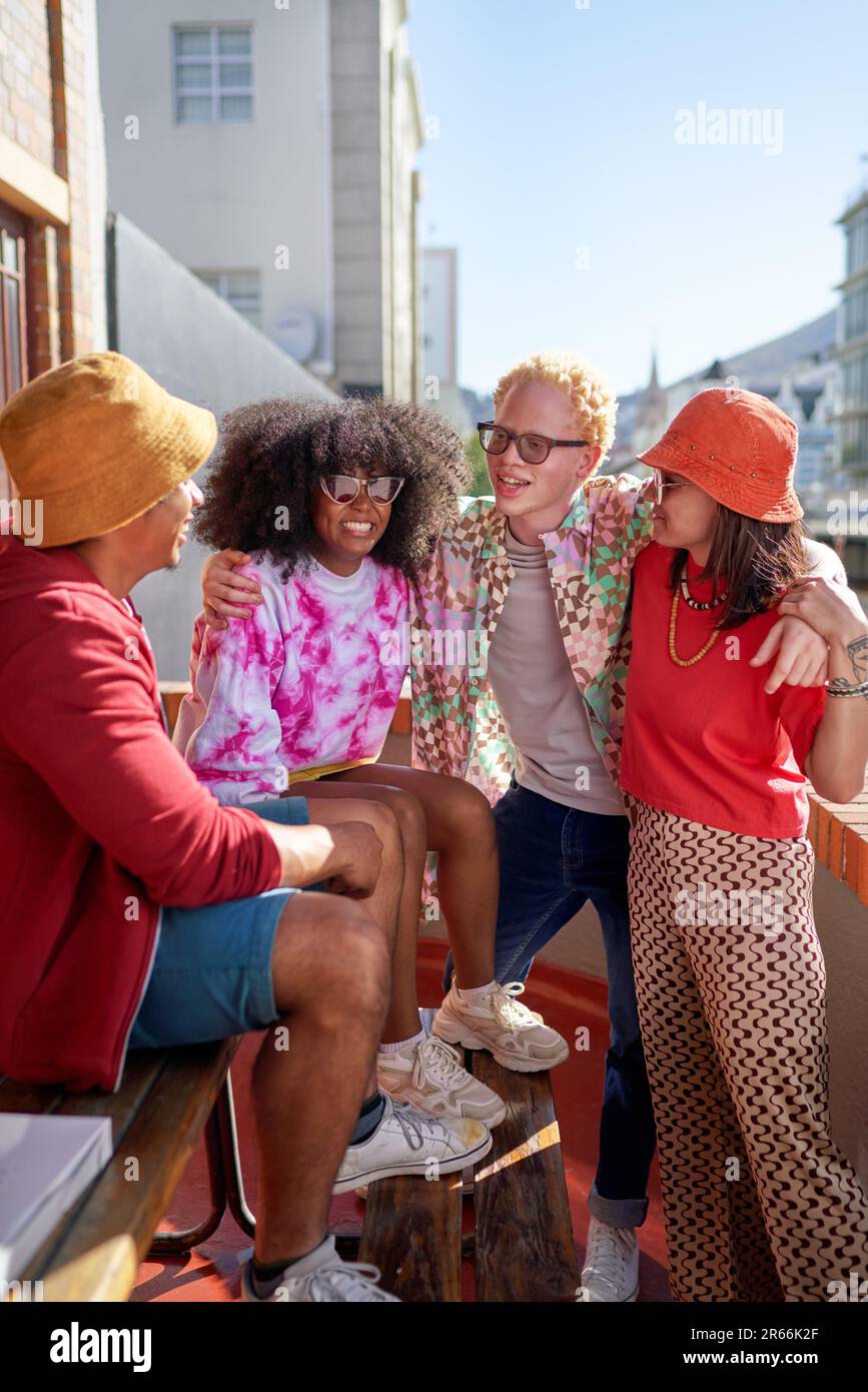 De jeunes amis heureux se traînaient, parlant sur le toit ensoleillé de la ville Banque D'Images