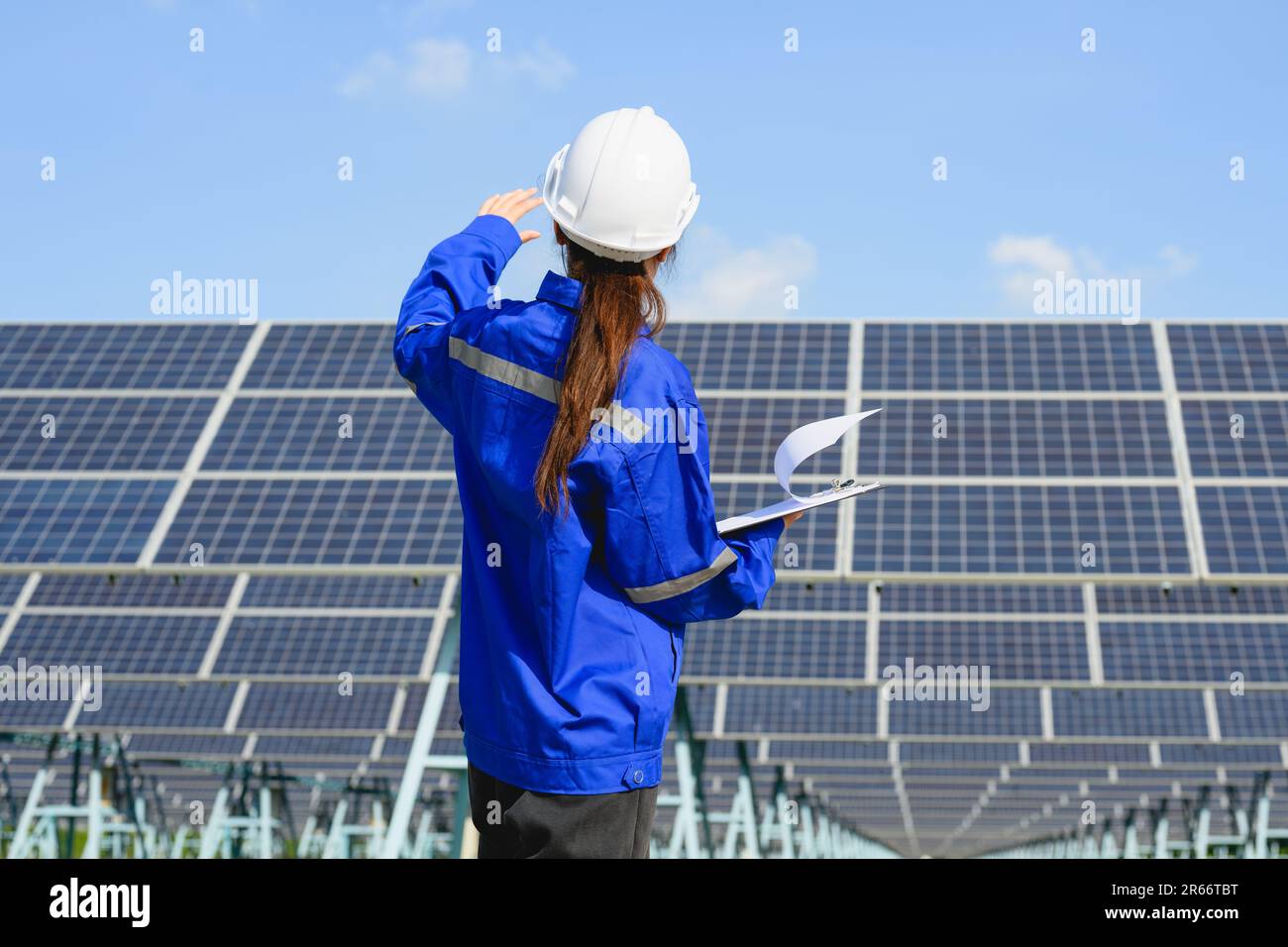 Femme ingénieure travaillant avec des panneaux solaires dans une ferme solaire Banque D'Images